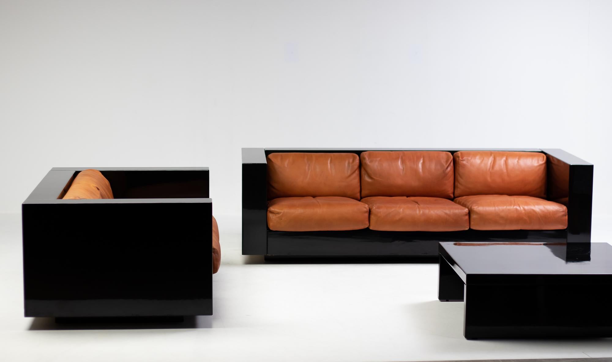 Massimo and Lella Vignelli for Poltronova 'Saratoga' living room set, black lacquered wood and cognac leather, Italy, 1964. 
This set of two-seater sofa, three-seater sofa and sofa table named Saratoga is designed by Italian designer couple Lella &