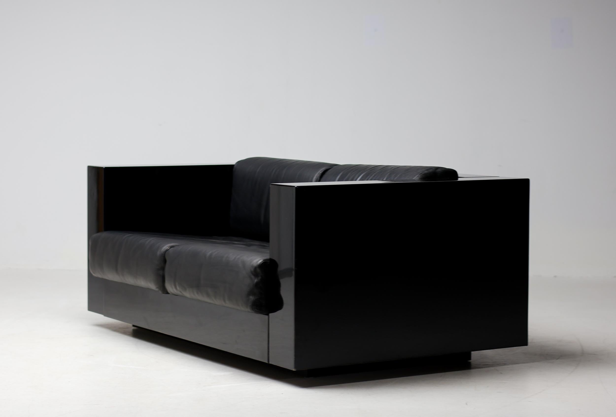 Canapé 'Saratoga' de Poltronova, bois laqué noir et cuir noir, Italie, 1964. 
Ce canapé deux places nommé Saratoga est conçu par le couple de designers italiens Lella & Massimo Vignelli. 
Les Vignelli étaient connus pour la clarté de leurs