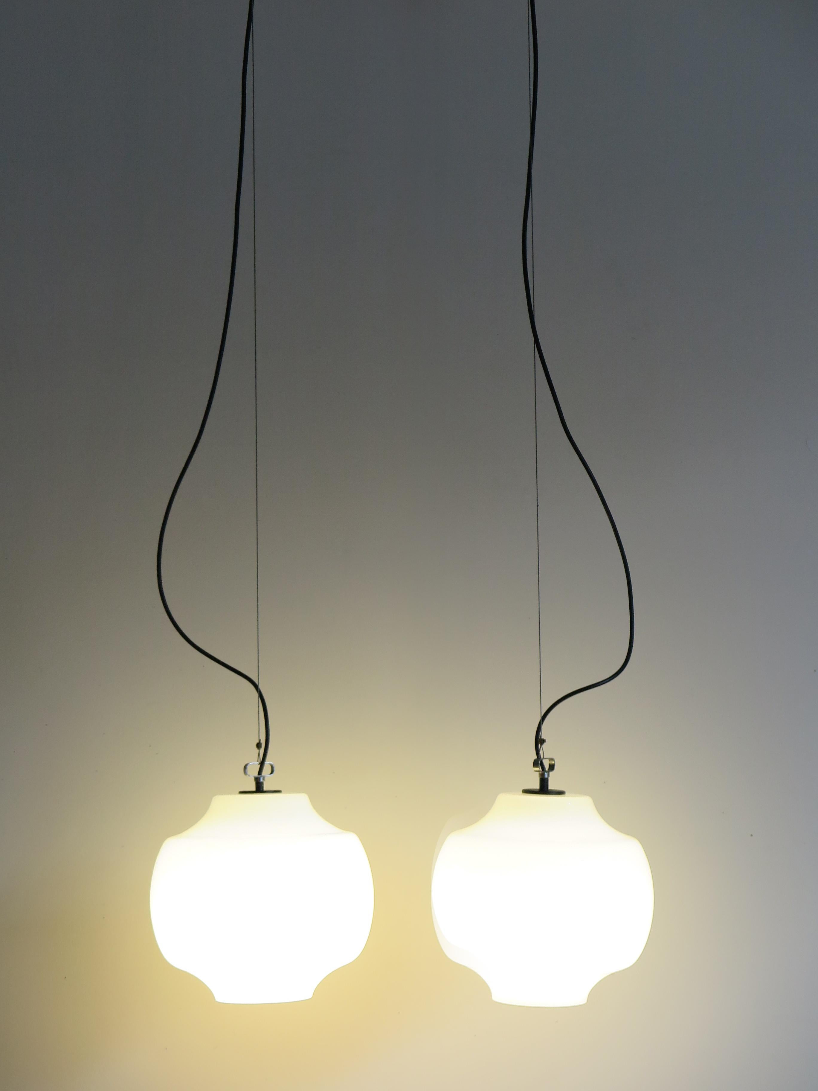 Italian Mid-Century Modern design set of two pendant lamps designed by Massimo Vignelli and produced by Venini with Murano glasses and details in lacquered metal, 1960s

Please note that the lamps are original of the period and this shows normal