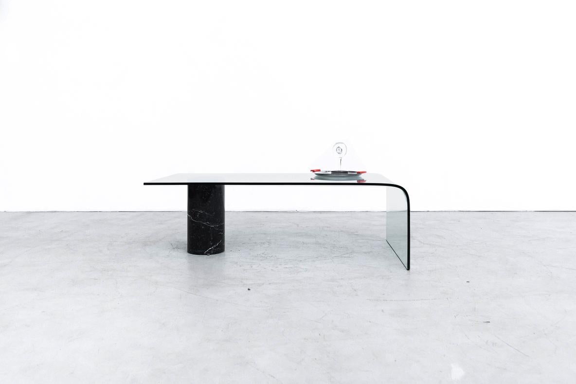 Table basse très impressionnante inspirée par Massimo Vignelli, avec verre courbé et support en marbre noir. Cette pièce impose votre présence et apporte un élément de design moderne à n'importe quel espace. En état d'origine avec une usure visible
