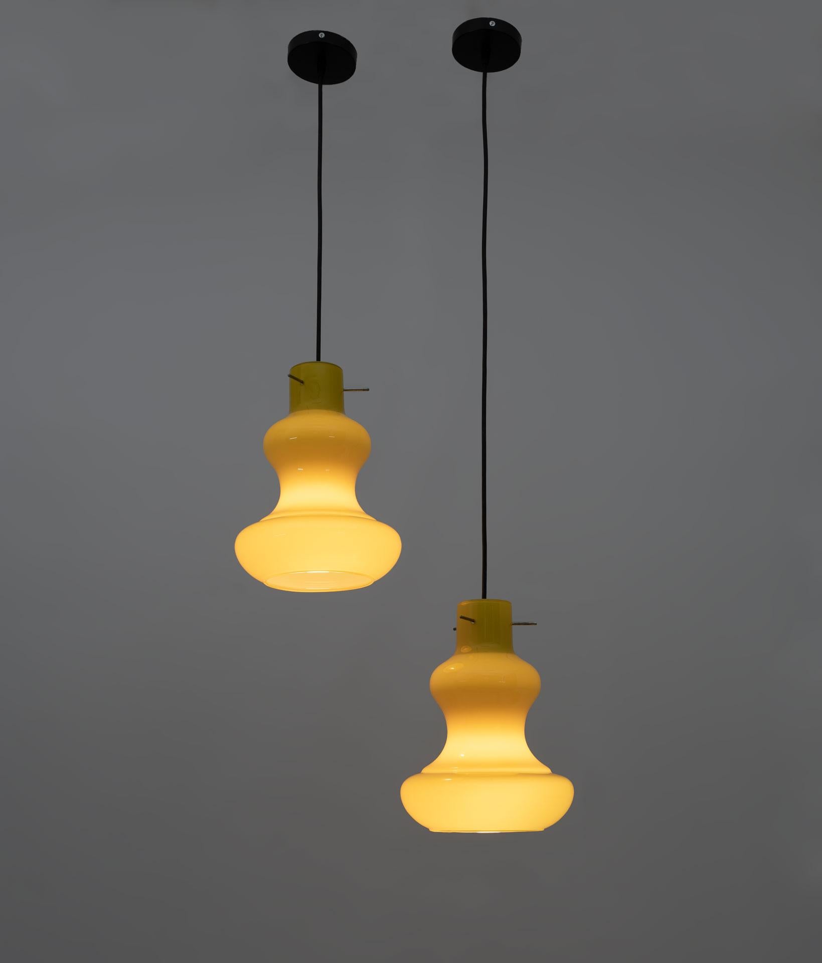 Pair of pendant lamps designed by Massimo Vignelli for the Vistosi glassworks in the 1960s, made of cased Murano glass. It has a beautiful bright yellow color and produces different shades of yellow when lit.
The indicated size refers to the glass