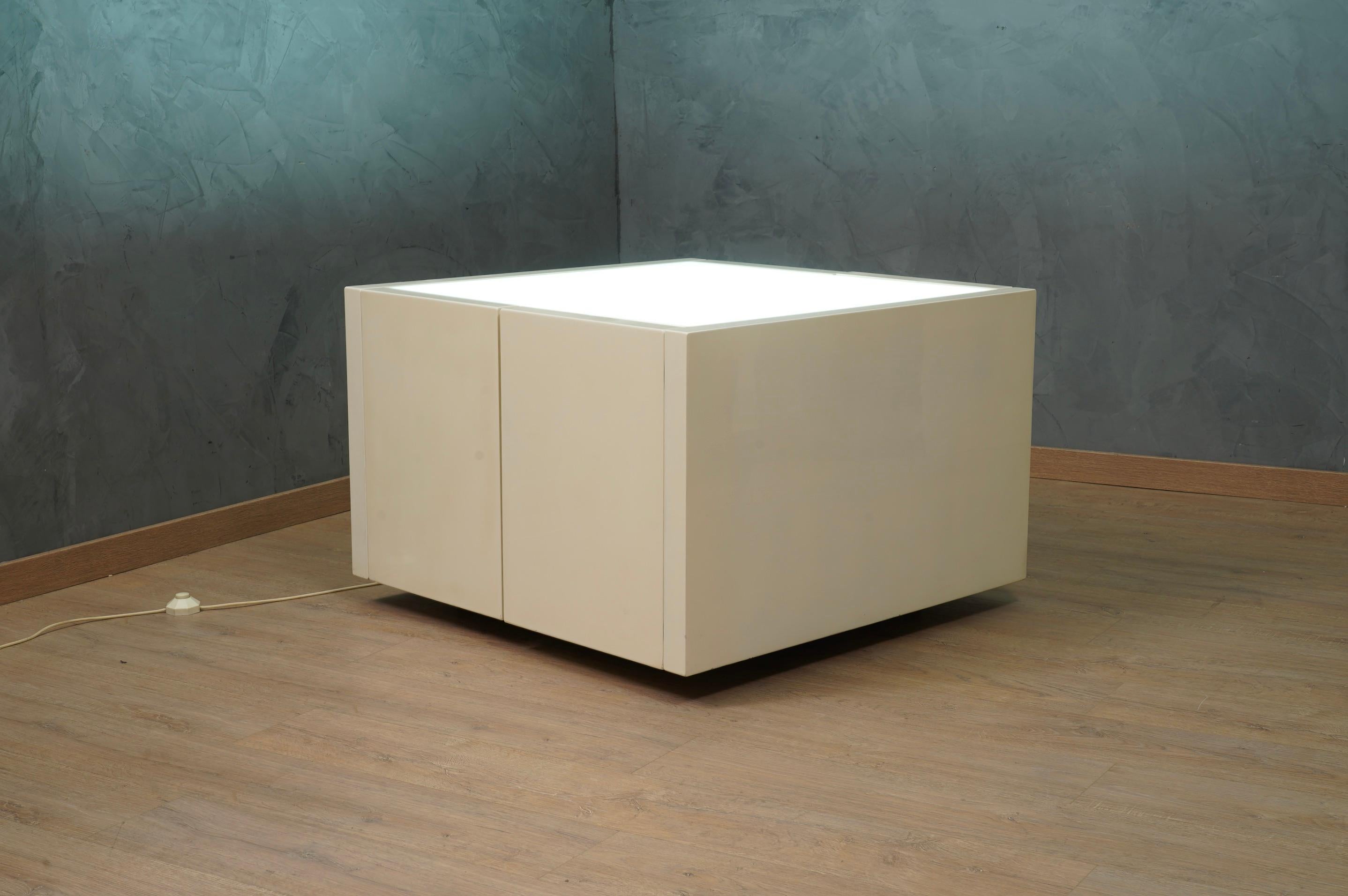 Historic side table mod. Saratoga with illuminated top in white lacquered wood. If you can design one thing, you can design everything, said Massimo Vignelli (1931-2014). Produced by Poltronova.

The side table is made up of a series of modules in
