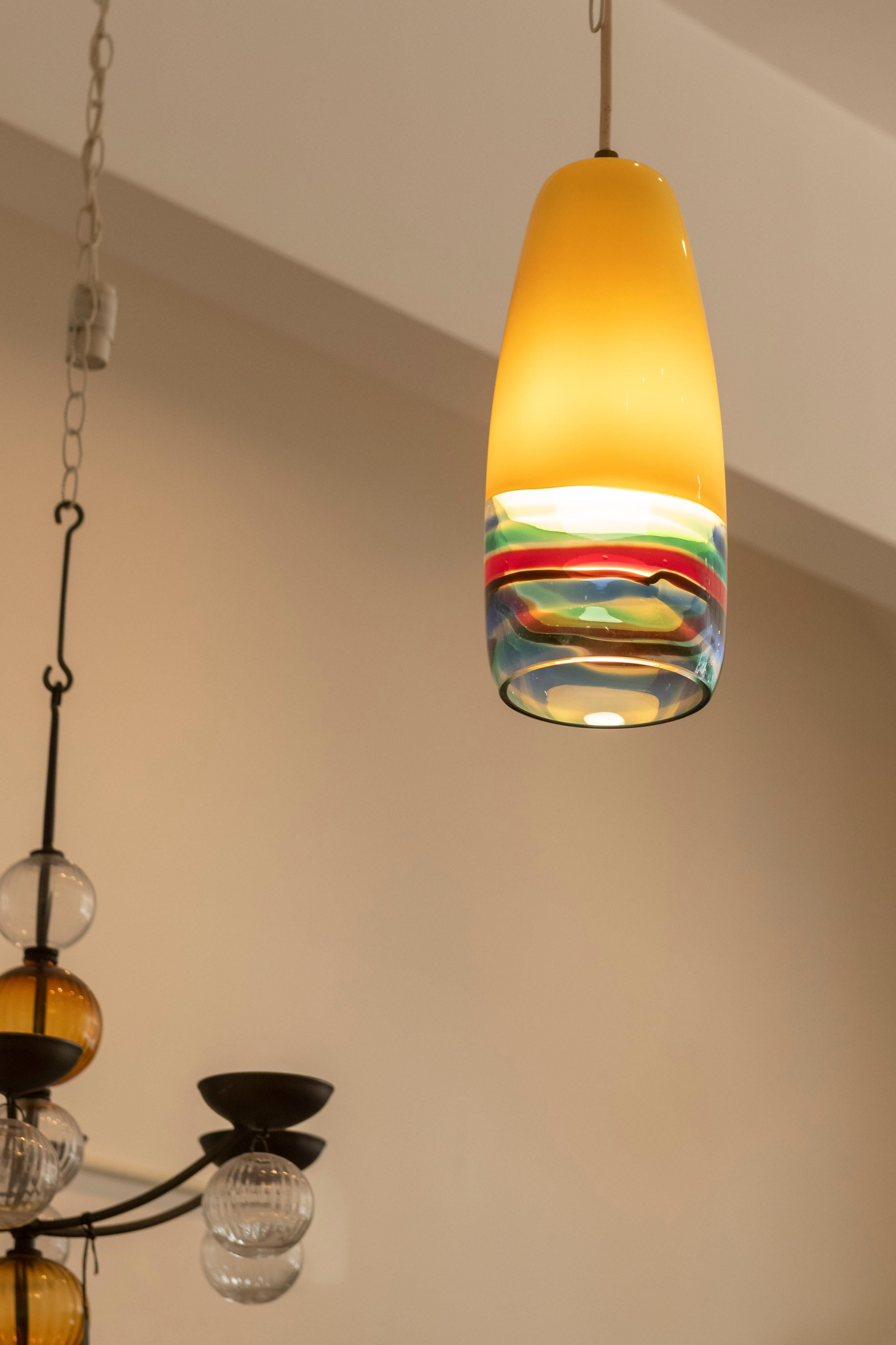 Yellow blown glass pendant lamp with colored bands also known as the 