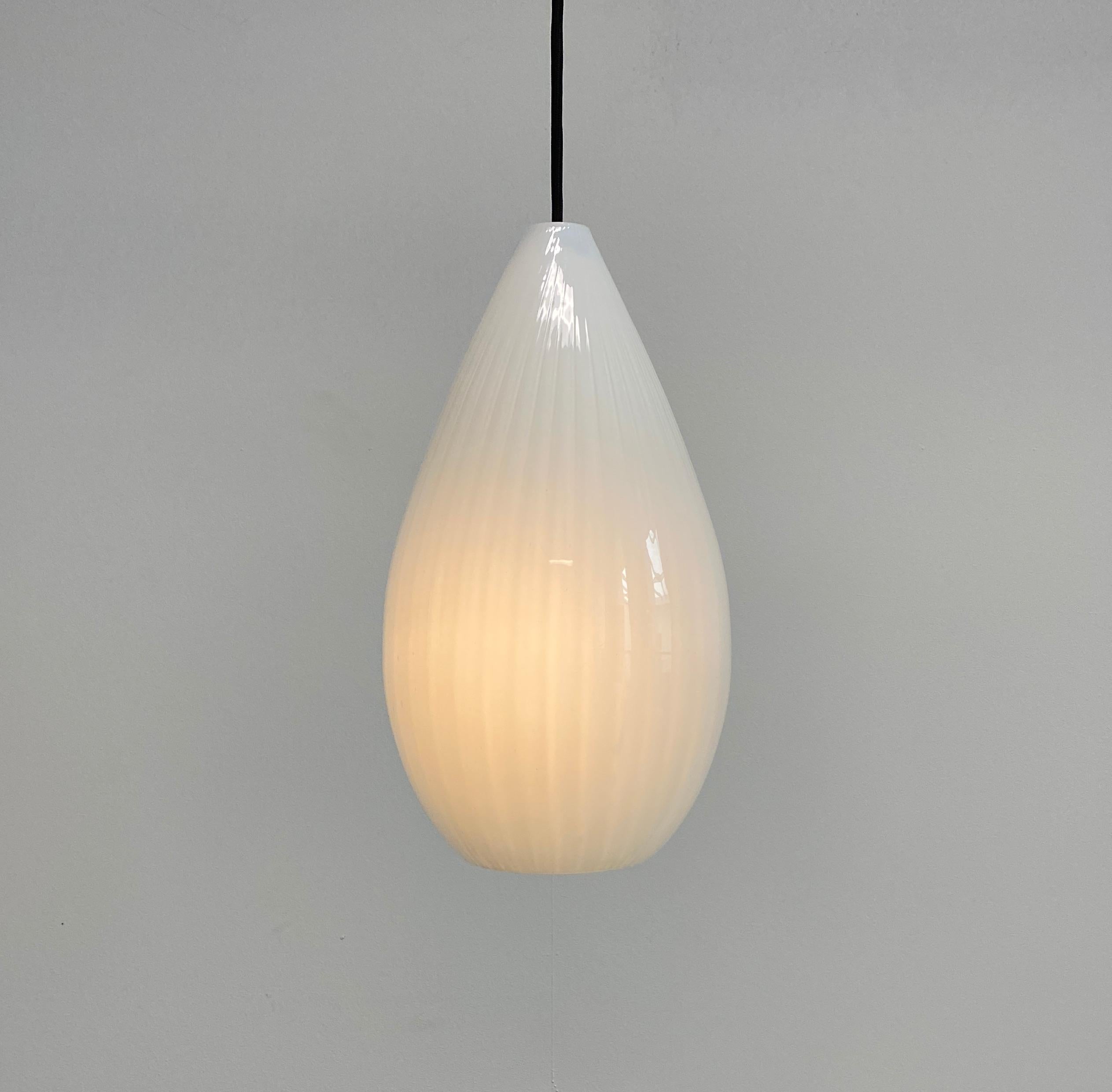 Large glass tear-drop pendant light, Italy, probably circa 1960's

Well-sized glass pendant fixture consisting of a beautiful blown glass shade with white on white stripes which also show quite delicately when the light illuminates. It's in very