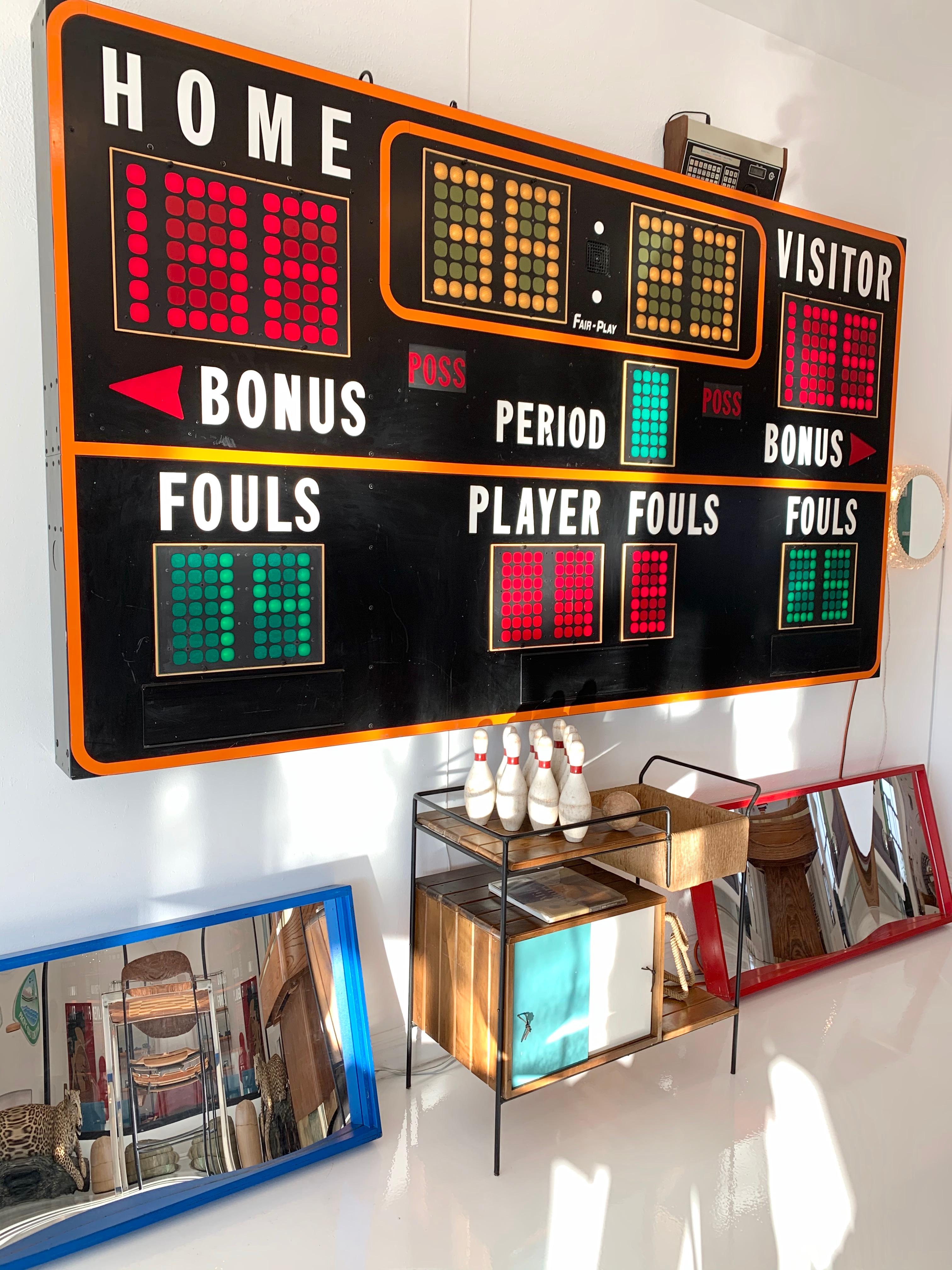 9 foot long basketball scoreboard by FAIR PLAY. Made in the 1970s. Rescued from an old barn in Kansas. Previously hanging at a small town high school outside of Topeka. Very rare black frame. Comes with working controller. Scoreboard features a