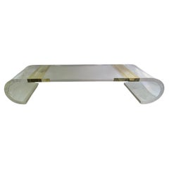 Table basse en acrylique à volutes massives avec pieds incurvés et détails en laiton États-Unis 1980