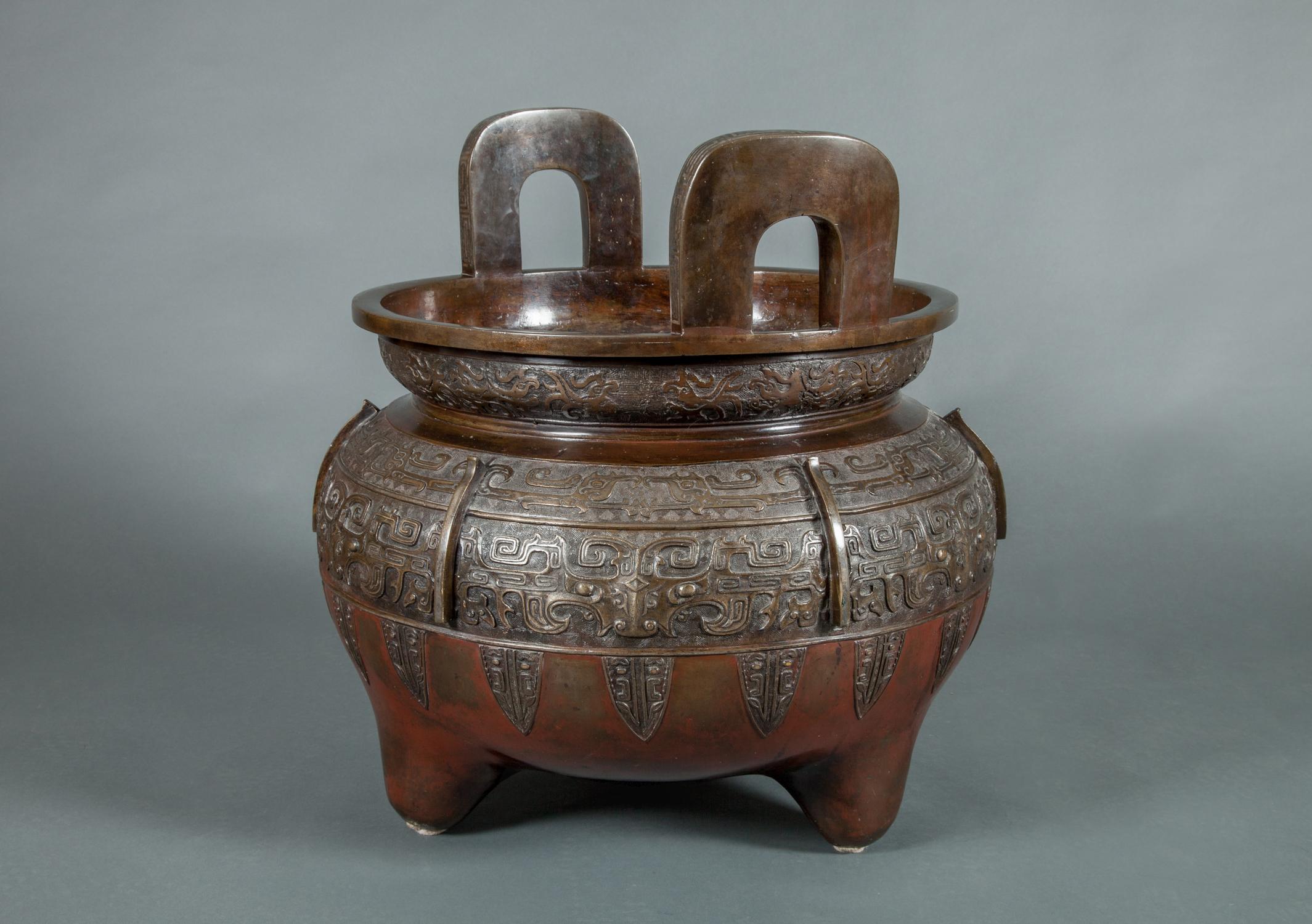 Massive 19th century Chinese Archaic style bronze censer, everted lip fitted with upright D-shaped handles with silvered metal inlay, above squat spherical body, raised on rounded feet.