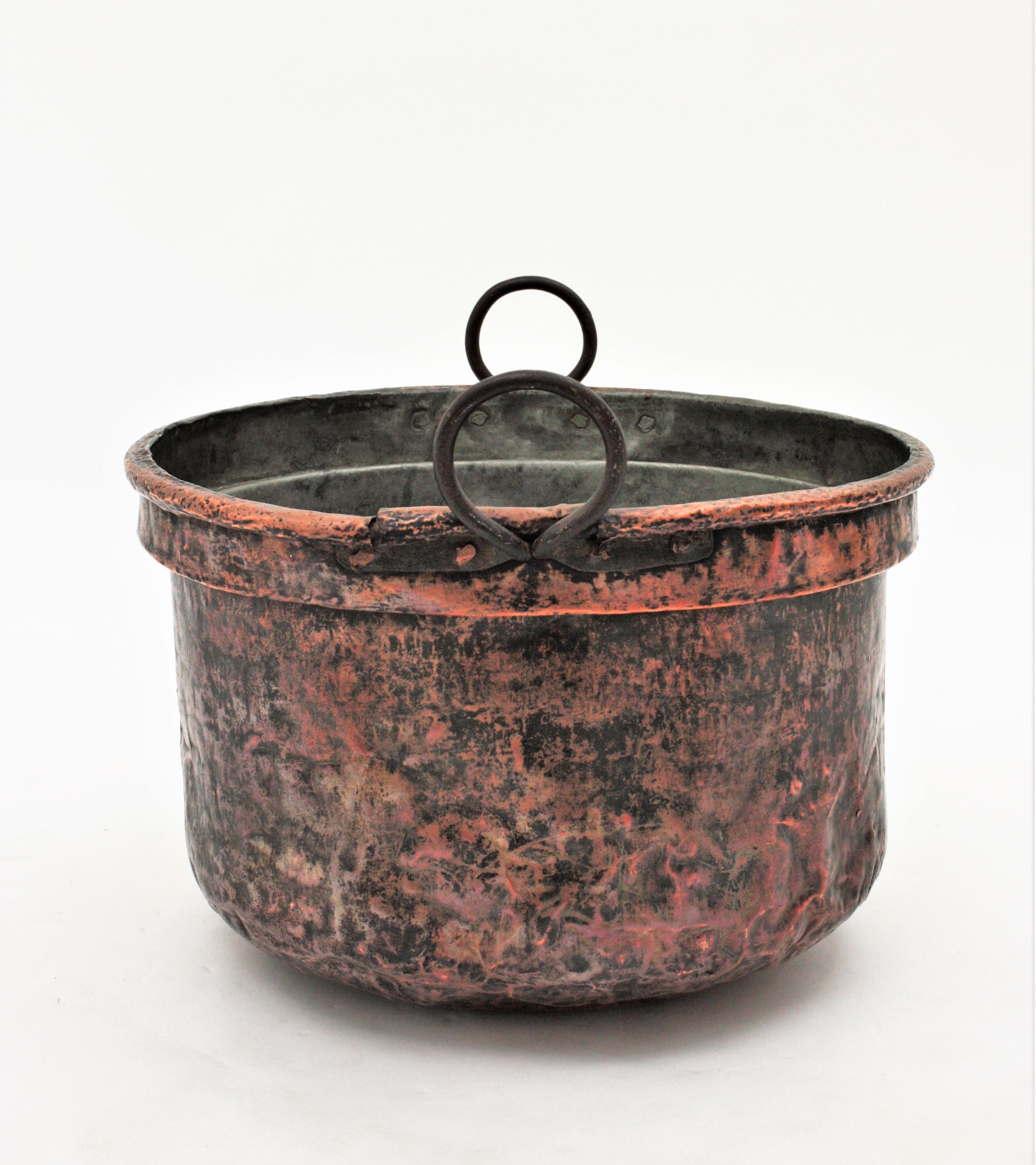 Oversized hand-hammered copper cauldron with iron handles, France, 1880s.
This handcrafted copper cauldron has a dramatic aged patina. The copper is heavily marked by the pass of time and it has a strong visual effect.
The iron handles are