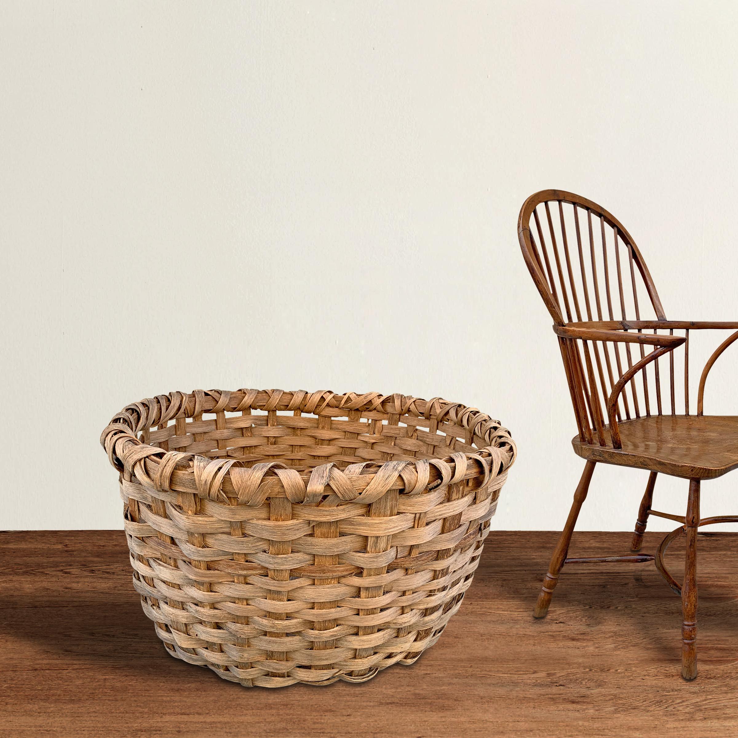 A massive late 19th century American oak splint basket with a double-banded rim and likely used for storing wool in a barn. We've been collecting basket for years, and we've never seen one this large. It's perfect for storing pillows, blankets, or