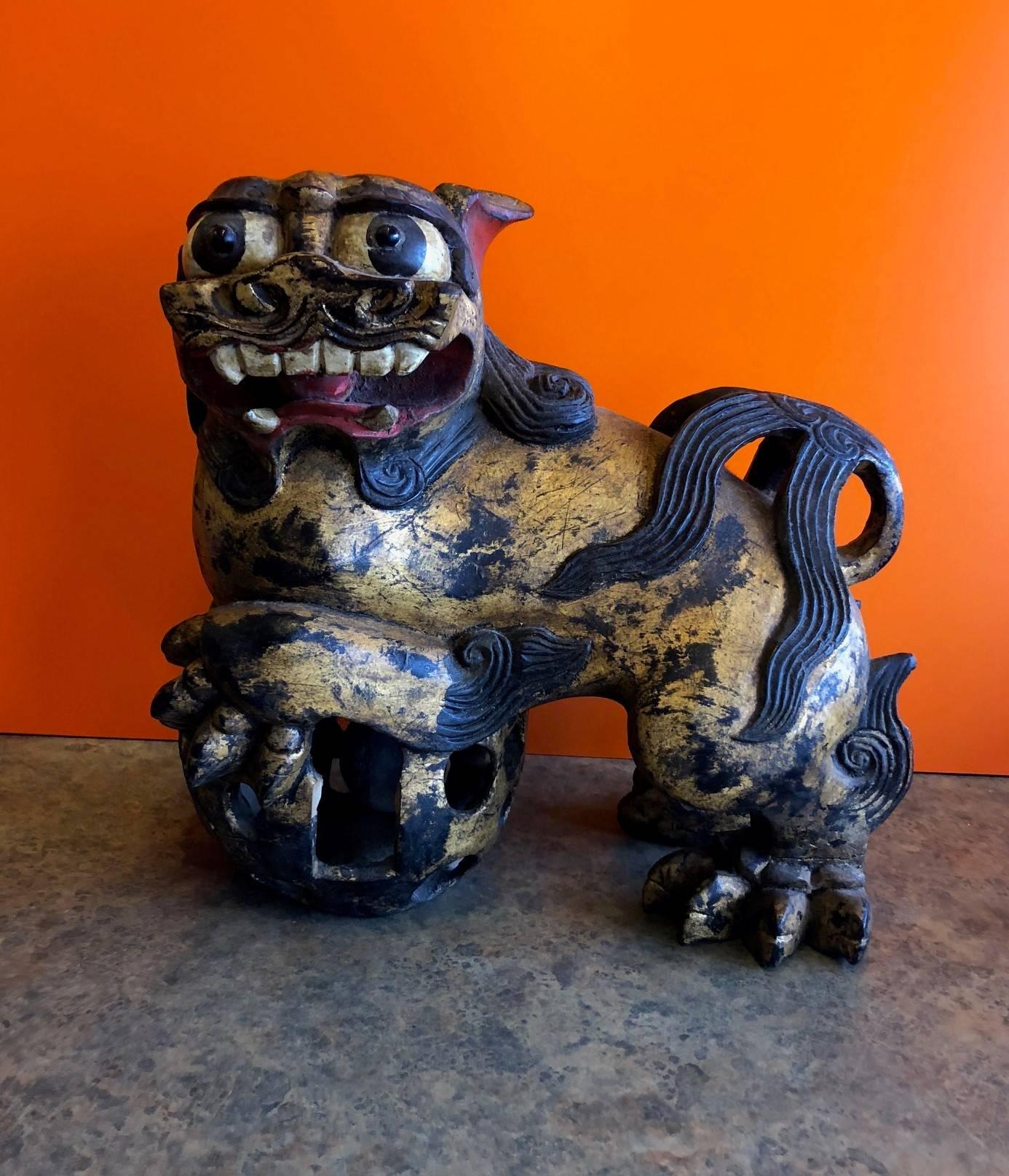 Incredible pair of poly-chrome hand carved gilt wood Chinese foo dogs, circa late 19th century. This massive and unusual pair are finely crafted with hand carved 