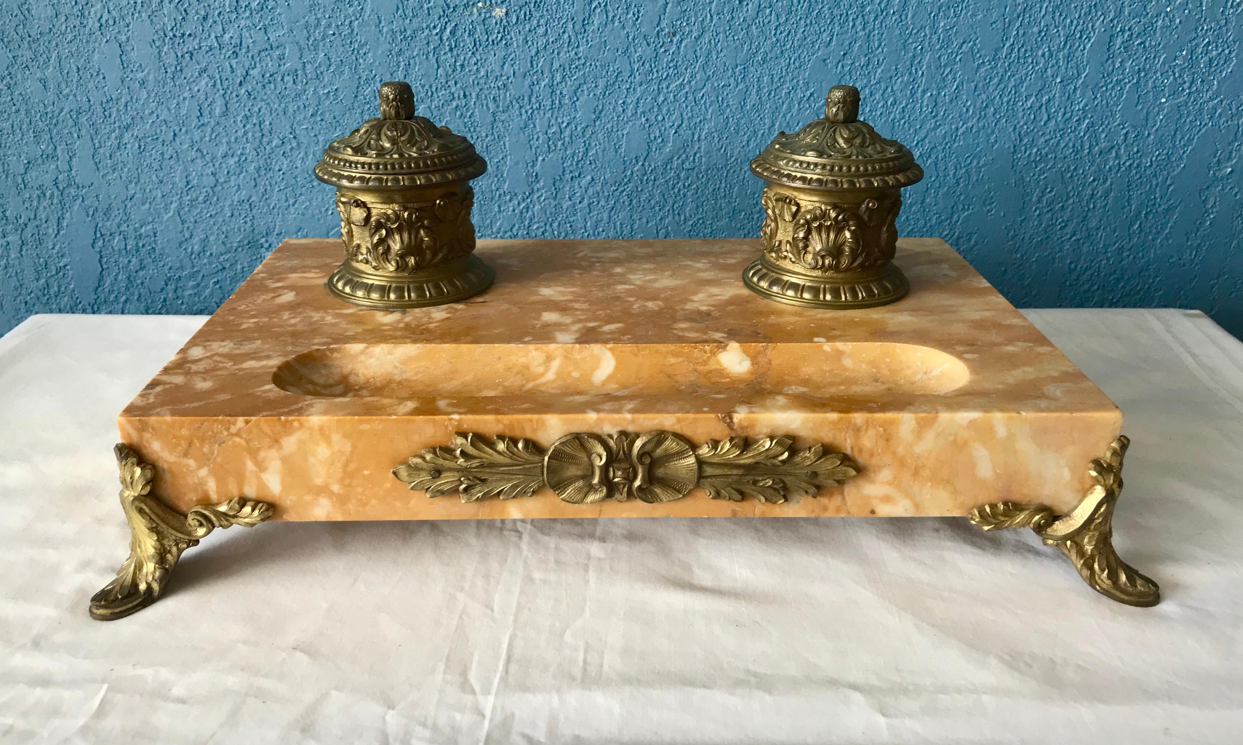 The stand is appointed with bronze inkwells and graceful feet.
Elegantly stylized.