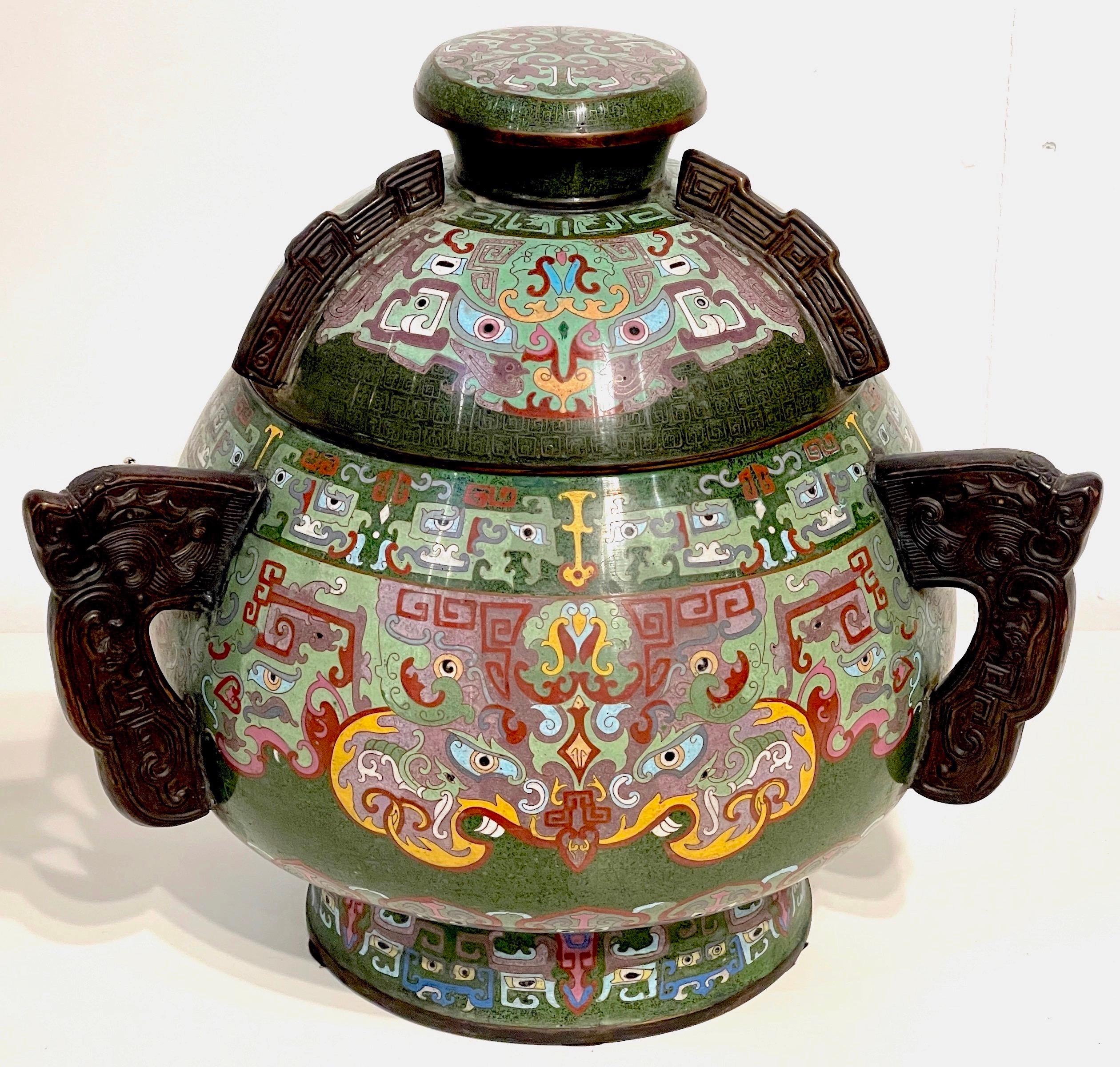 Massive 20th Century Chinese Archaic Style Cloisonné Covered Urn/ Censor 
China, 20th century 
A substantial example, intricately enameled in the Archaic style, with three cast and patinated bronze archaic handles.
Overall measurements;
17 inches