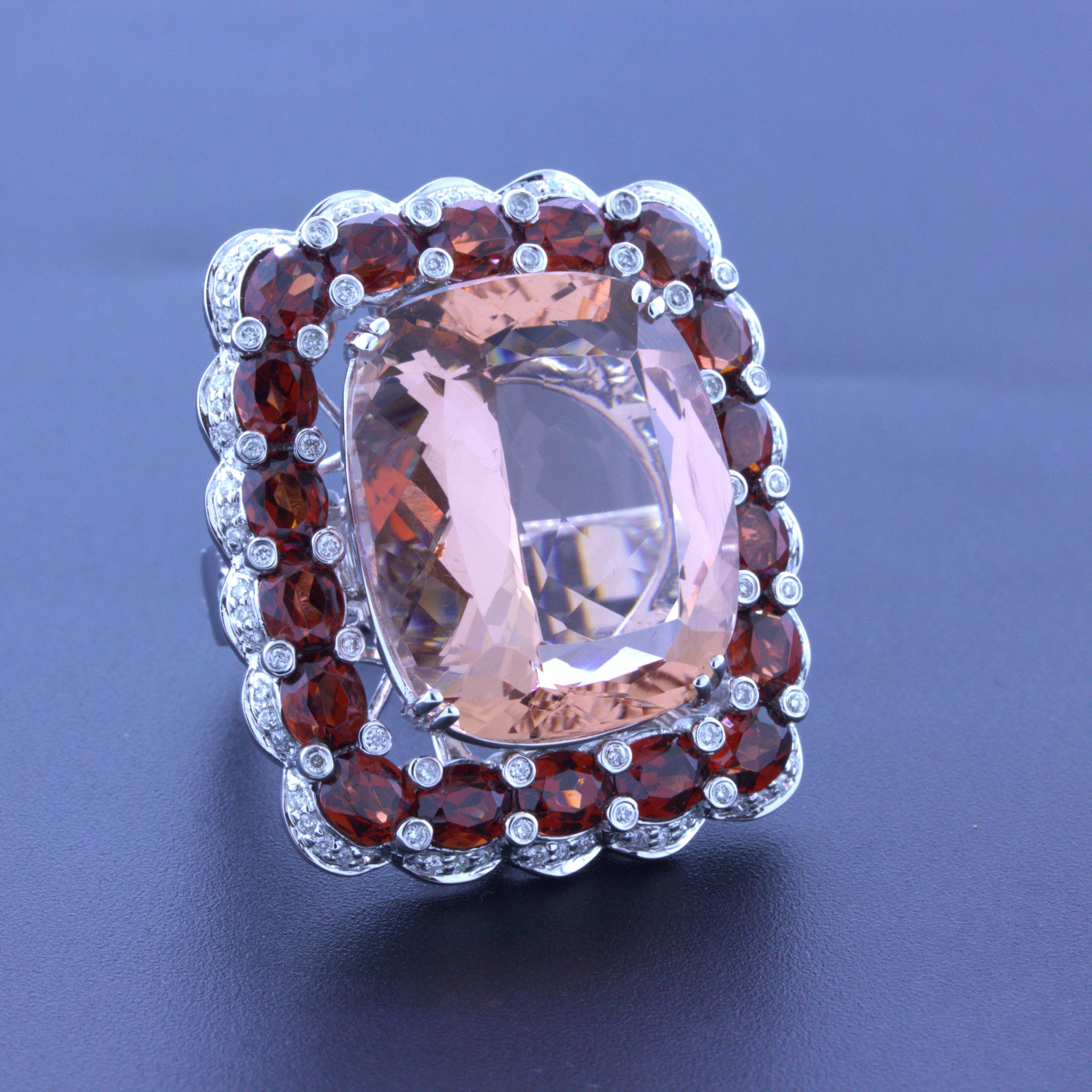 A very large and unique cocktail ring featuring a substantial 30.39 carat morganite! The morganite has a precise and proportional cushion-shape along with a lovely rosy-peach color that glows in the light. It is complemented by a halo of oval-shaped