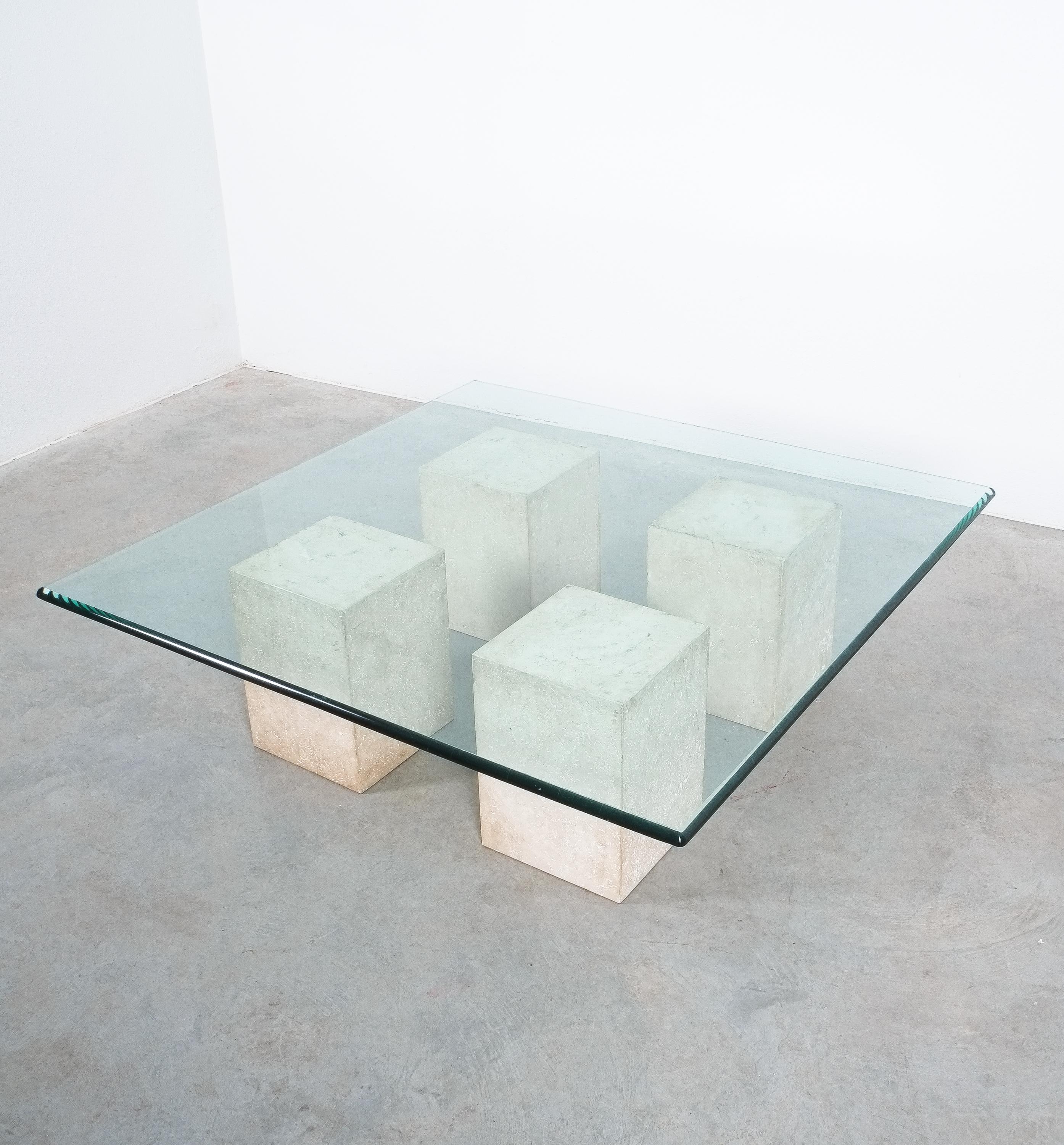 Monolithic travertine & glass coffee table Massimo Vignelli, Italy, circa 1970.

Large coffee table composed of 4 monolithic blocks from travertine and a 55 x 55 inch glass table top.
Total weight is about 180kg. Each block has about 20kg and the