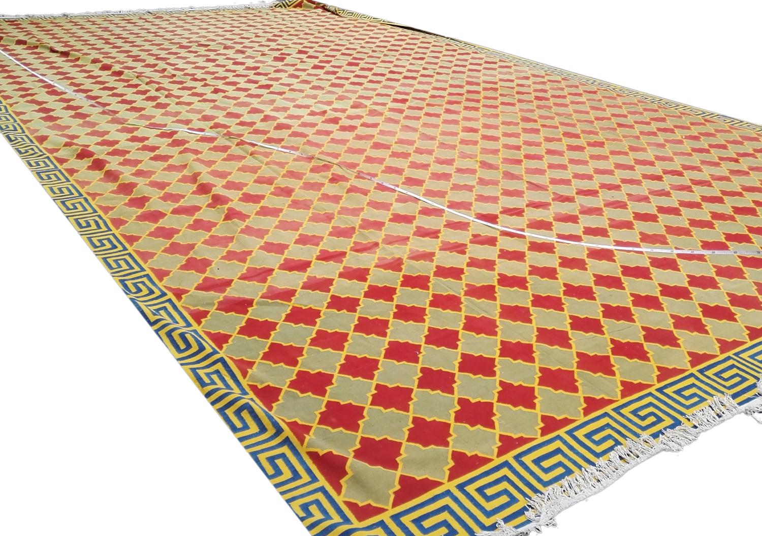 This is an antique palace size Indian Dhurrie kilim woven circa 1920 - 1950 and measures a massive 890 x 545 CM in size. It has an all-over design with rows of repeating red and green medallions connected with a yellow outline lattice design This