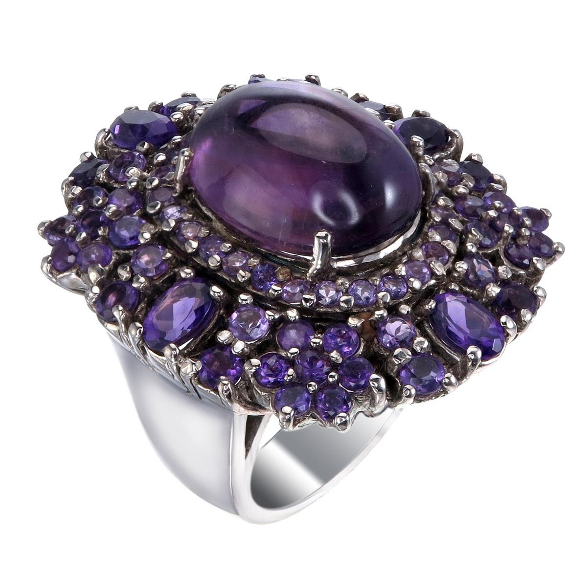 Ginormous Amethyst Cluster Cocktail Ring forged in 925 Sterling Silver.
The massive amethyst cocktail ring is a bold and striking piece of jewelry that exudes luxury and style.
Around the large cabochon sits 74 smaller amethysts in a floral