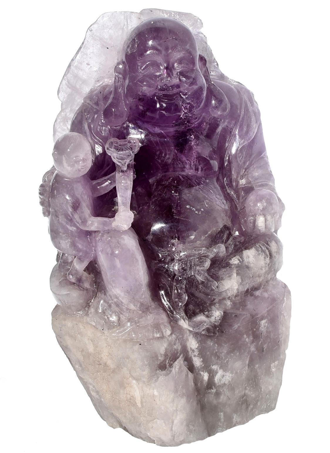 A huge Amethyst Buddha that weights 14.6 lbs. The sculpture is of the Happy Buddha, shown here with a boy holding a Ruyi, scepter. The boy is also sitting on a tael of gold, called Yuan Bao, which is a symbol of wealth. A lotus leaf covers the back
