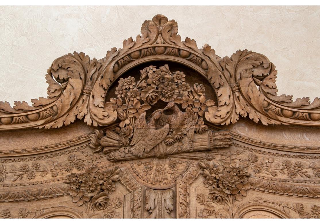 Massive and very well carved in the Traditional French Craftsman style, in a rustic natural wood finish. The bonnet with a carved leafy deep crest with love birds perched on a quiver. Raised panels on the doors and sides.
Overall heavily carved