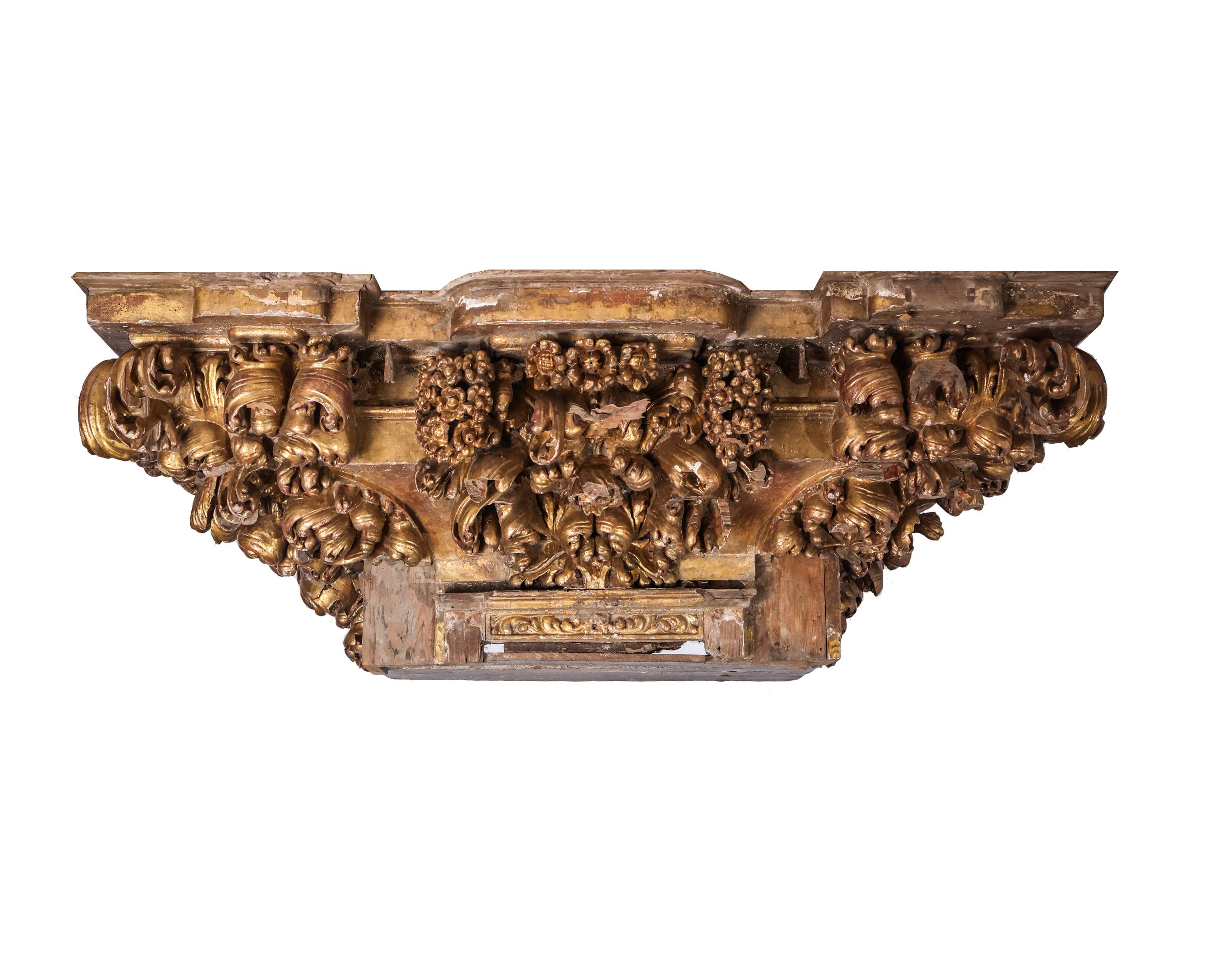 A truly phenomenal antique architectural gilt pediment salvaged from an interior structure in France, this massive structure is carved out of wood with incredibly ornate detail and its original gilded finish intact. The carvings of acanthus leaves