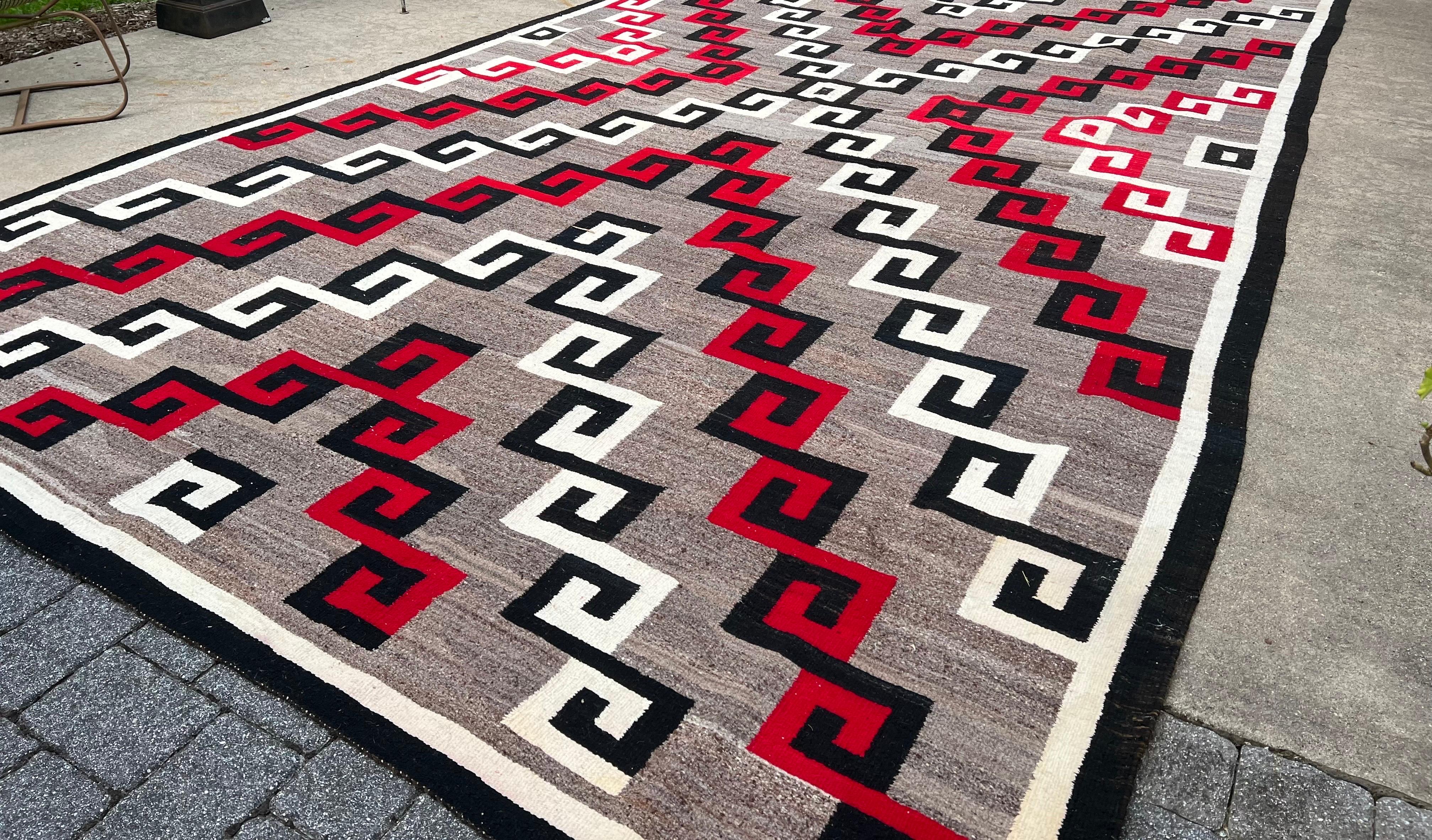 An exceptionally large and rare antique Navajo rug dating from the 1940s to the 1950s. This striking Ganado carpet boasts a vivid 