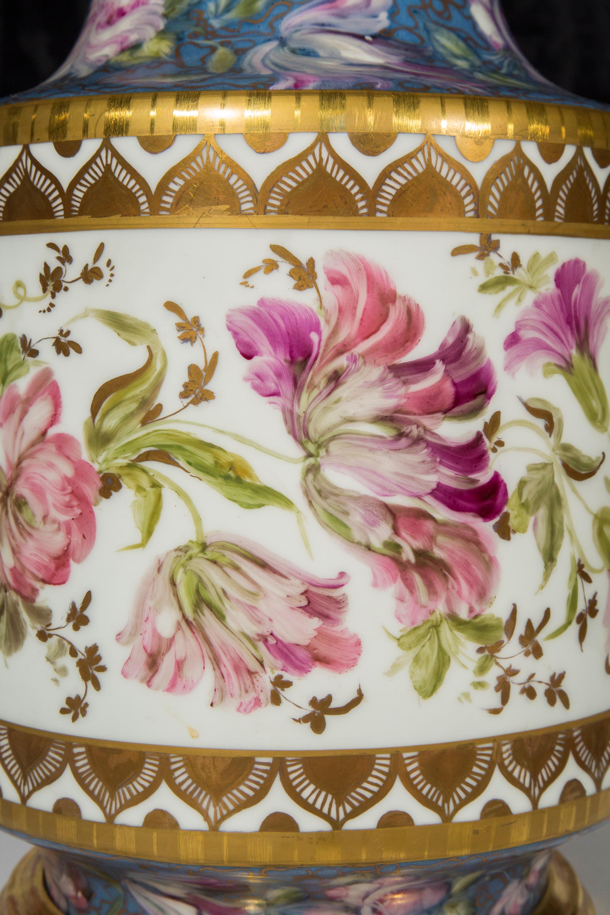 An impressive, very decorative porcelain table lamp, gilded and hand-painted with flowers. On a water-gilded base. Continental, late 19th century.

Height excluding fittings 22.5 in / 57 cm.