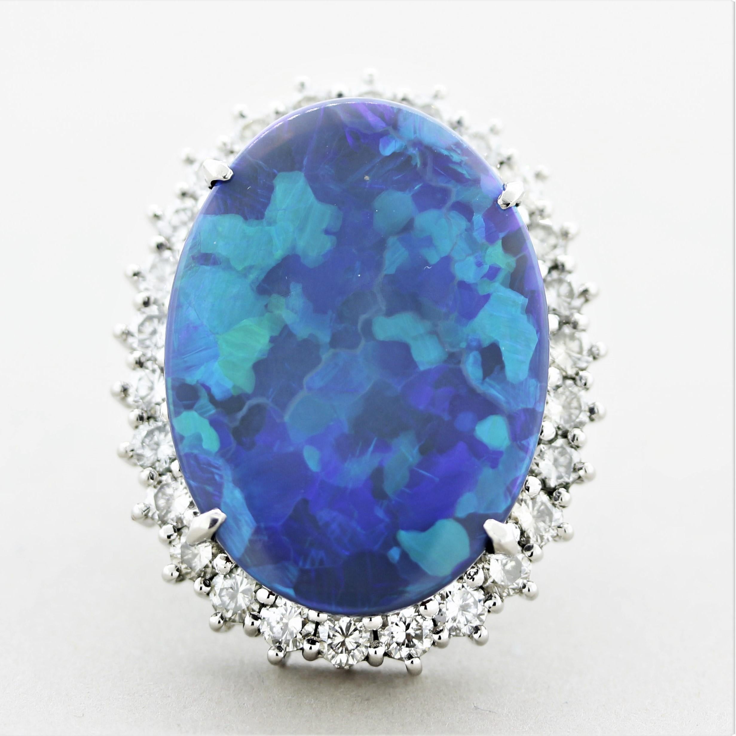 A large and exceptional black opal from Australia! It weighs in at a whopping 24.95 carats and has great play-of-color. Bright flashes of green and blue can be seen across the opal over its dark black body color. It is accented by 4.10 carats of