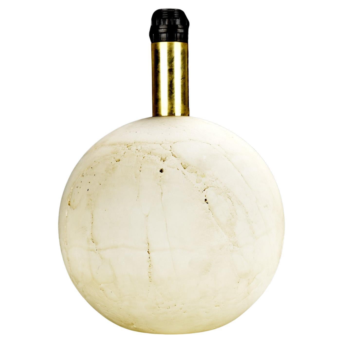 This is a massive and extremely heavy spherical table lamp base made of travertine marble, crafted in Italy during the 1960s. 

The solid stone construction gives it an impressive weight and a substantial presence, making it a standout piece.