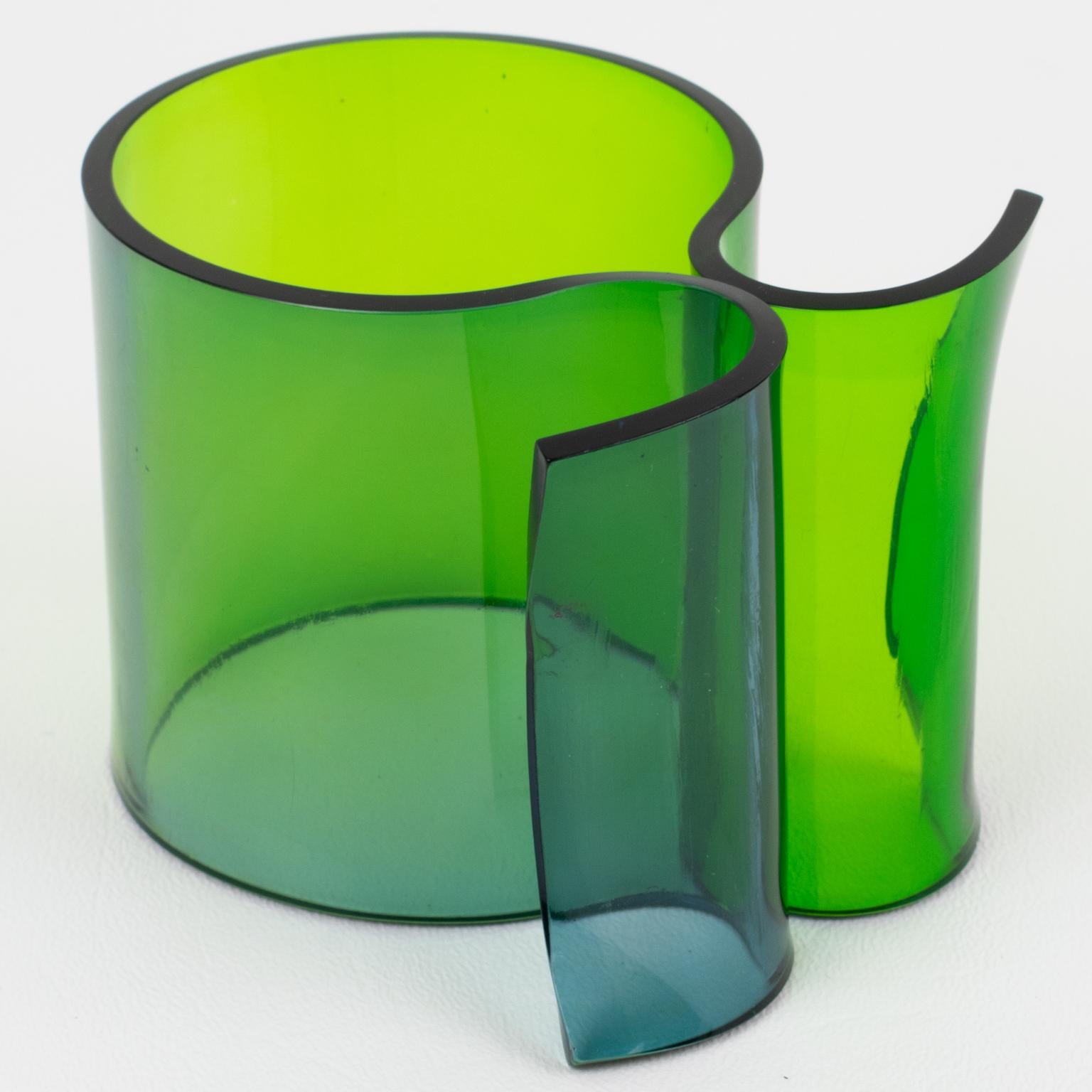 Este impresionante brazalete escultórico italiano de Lucite o plexiglás de la década de 1980 presenta una forma de pajarita maciza con un efecto de coloración graduada. Los colores van del azul Egeo al verde esmeralda. No hay marca visible del
