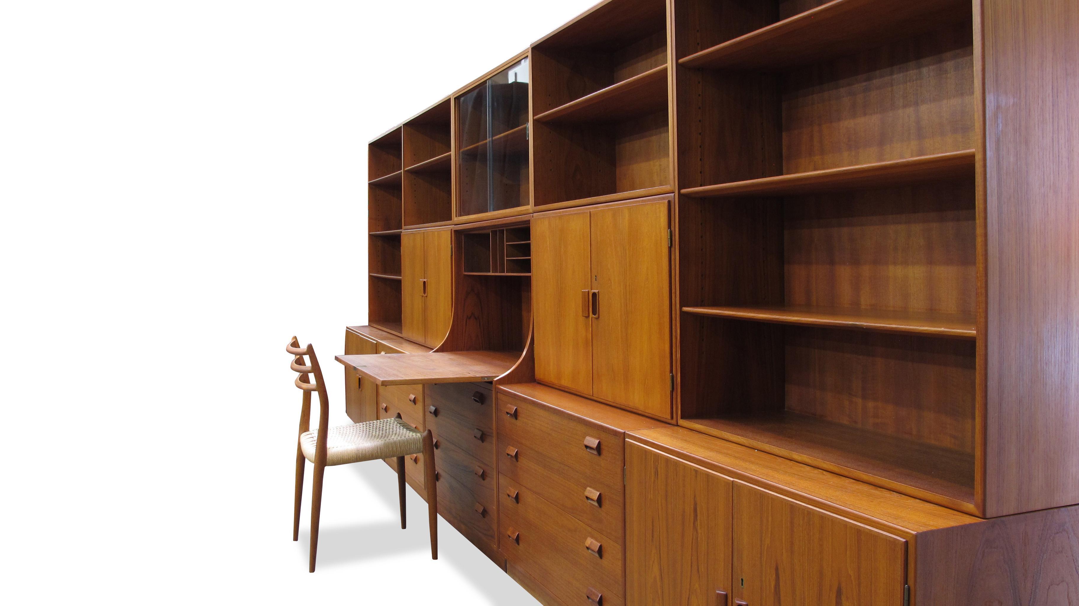Massive teak wallunit designed by Borge Mogensen for Soborg Mobelfabik, Denmark. This fully interchangeable wall system is crafted of old-growth teak, and consists of twelve cabinets; including lower storage units and hutches. 2- lower cabinets with