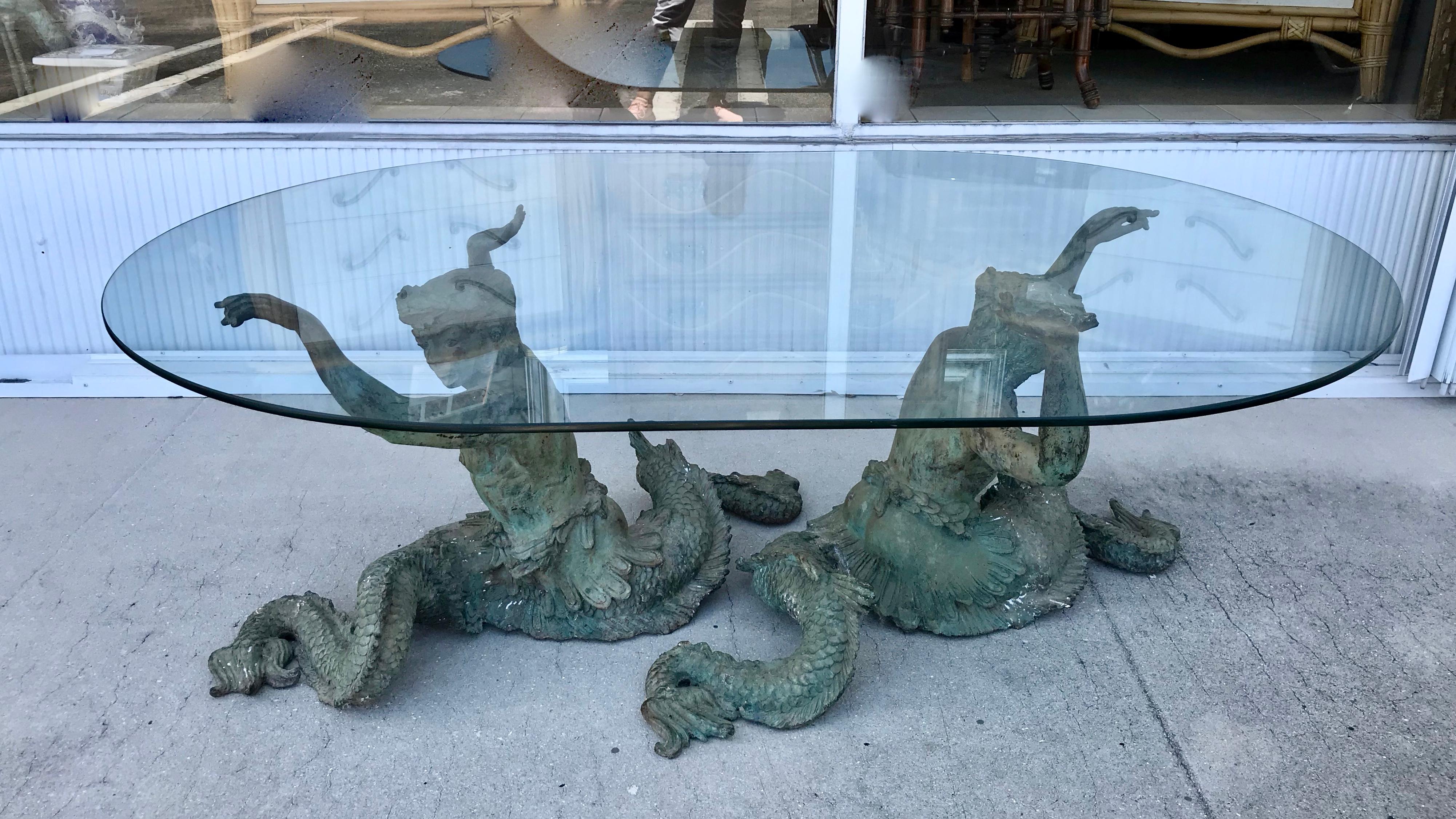 The table is fashioned with large mythologic mermen with enormous fish-like tails.
The mermen are designed to hold a large piece of glass (as pictured).
Each figure is nearly 3 feet long.
This is an especially dramatic table
Dramatic in scale,