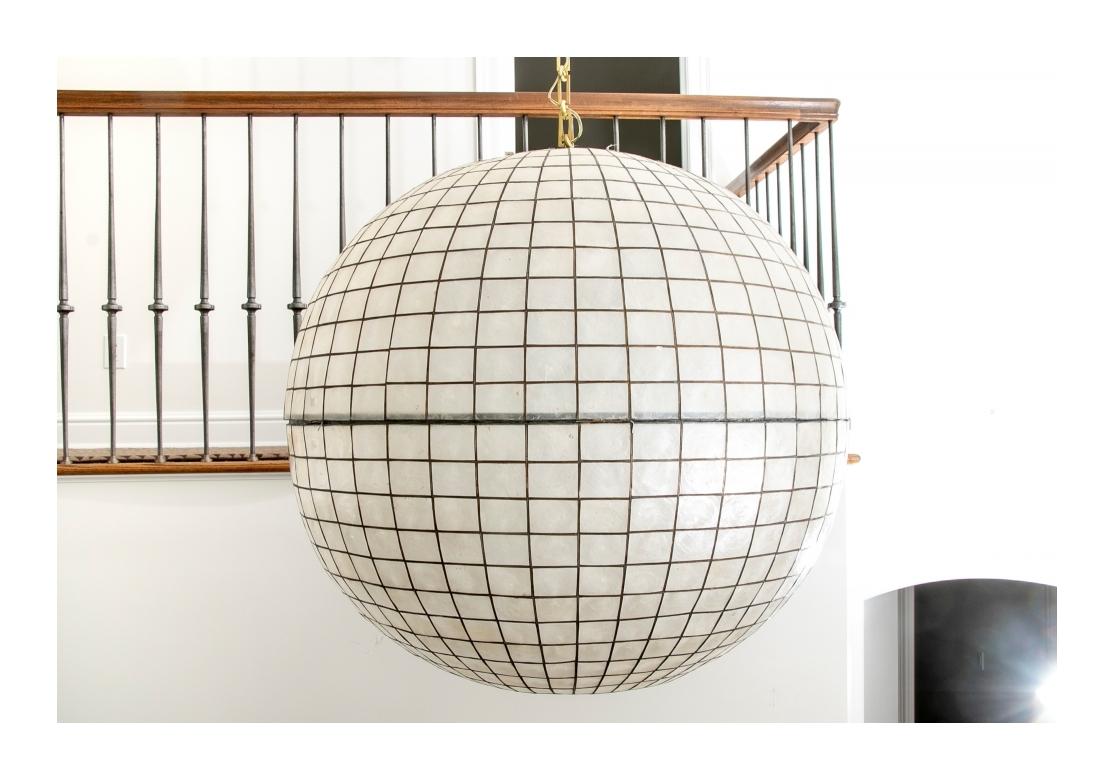 An enormous midcentury style Capiz shell ball form pendant chandelier with graduated lattice design.
Dimensions: 32