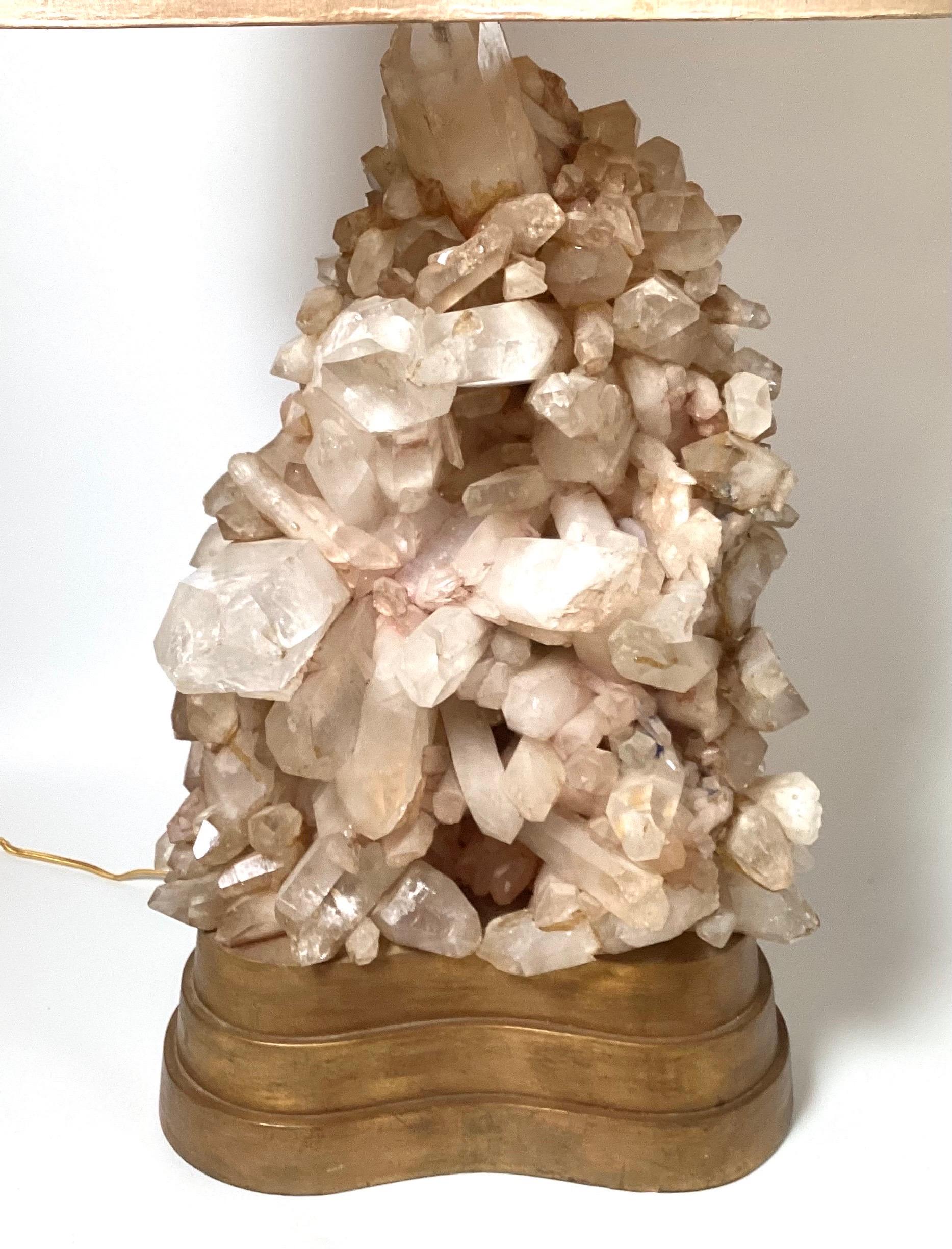 Large studio made table lamp with quartz crystals by Carole Stupell, American, 1950. The naturally formed rock crystal spears rest on a tiered custom-made original giltwood plinth base. The shade is an original kidney shape and is in good condition