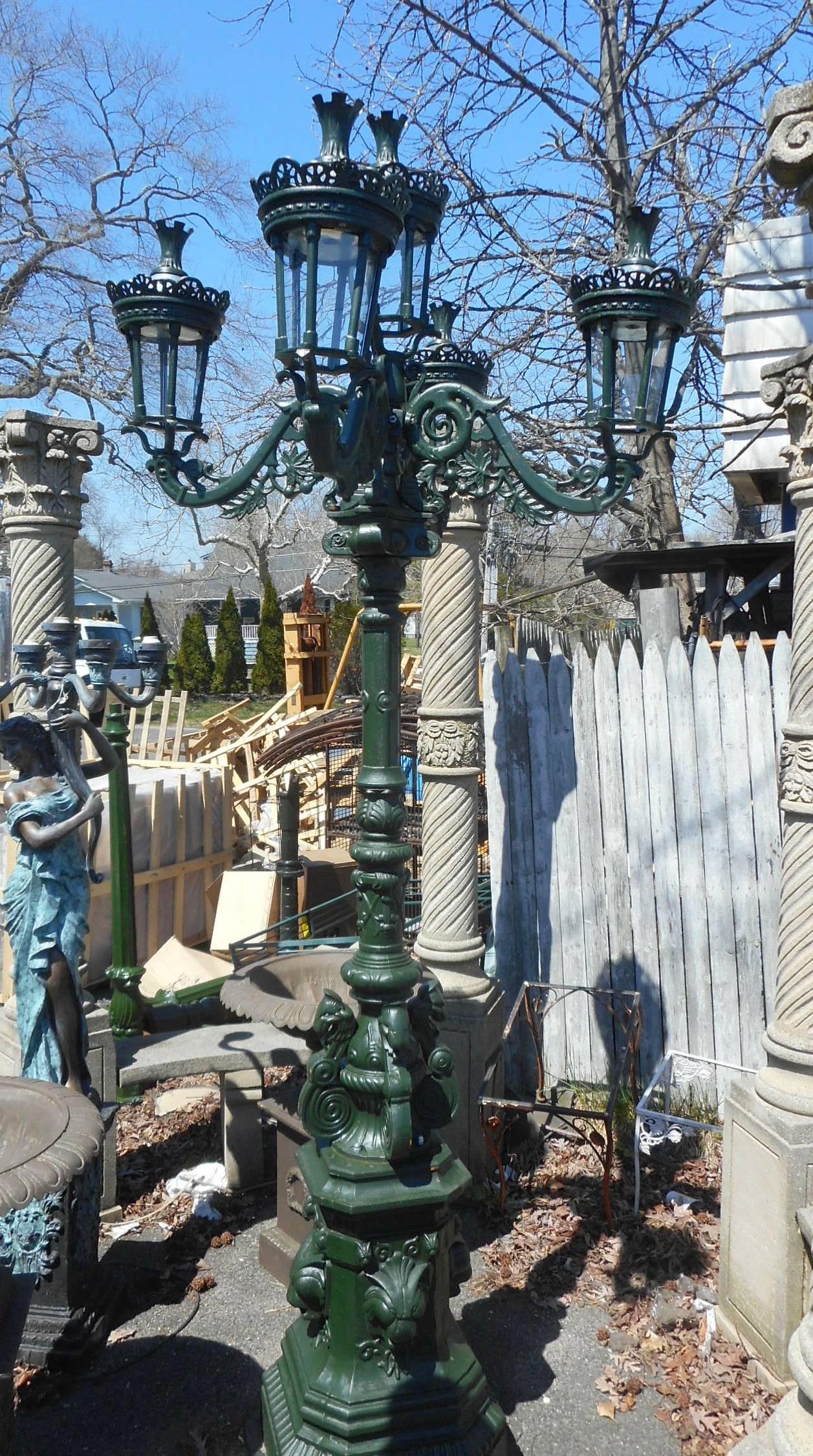This impressive cast iron street lamp has five lanterns on the top and sits on top of a large pedestal base. Wonderful design with cast lions along the base and four arms on the top with scroll detail. This amazing 10 foot tall piece is sure to make