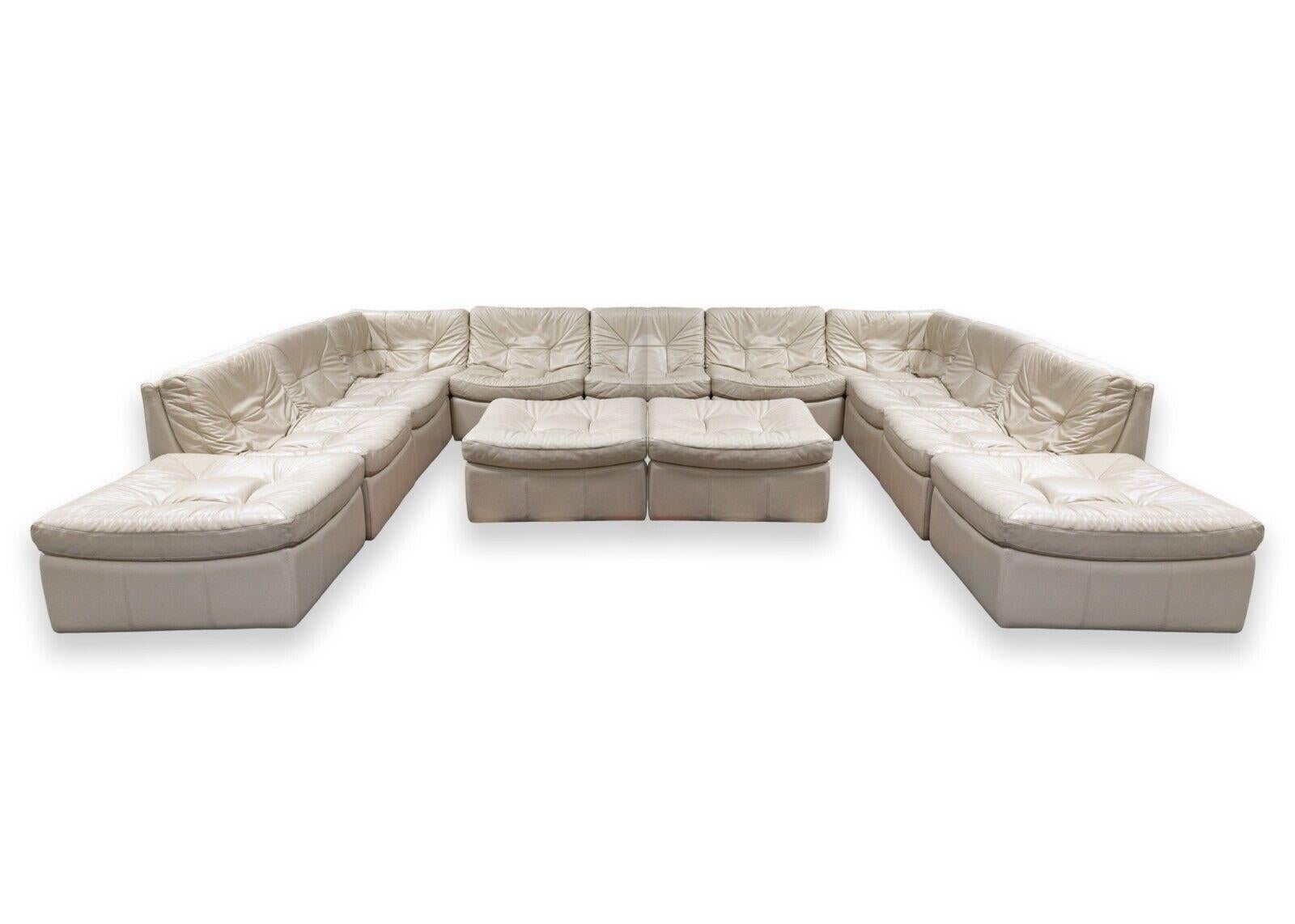 A Chateau d'Ax 13 piece sofa sectional. This is an absolutely massive leather sofa sectional featuring a 13 piece design, including 4 modular ottomans. The leather on this sectional is a very clean cream/beige color, very neutral and very