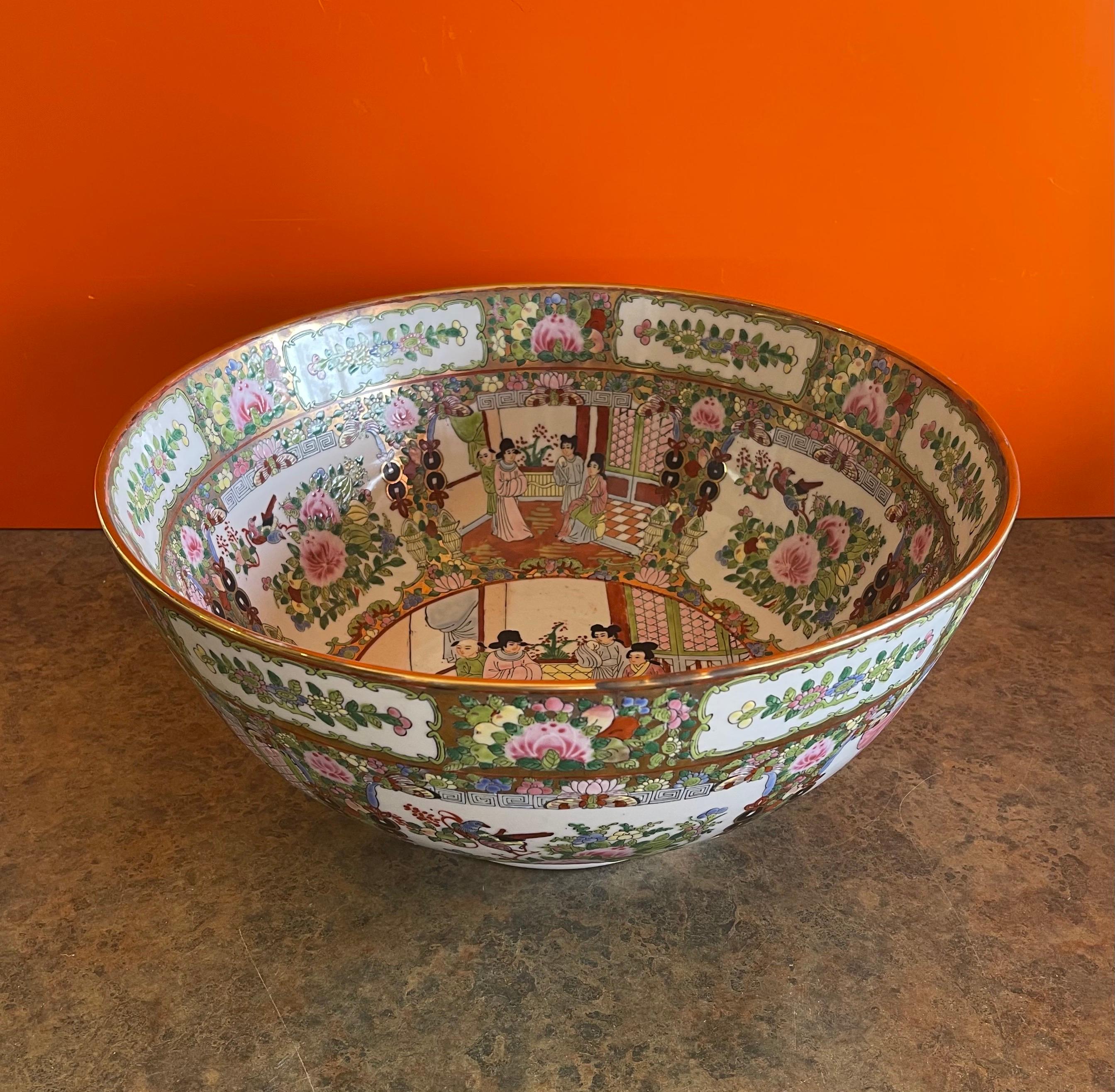 Massive Chinese export hand painted rose medallion porcelain bowl, circa early 1900s. This gorgeous bowl has a wonderful traditional design and is in very good antique condition with no chips or cracks. The piece measures: 16