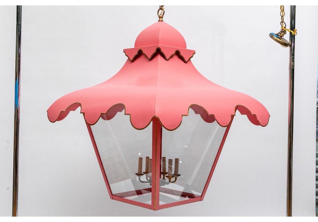 A massive Mid Century metal lantern fixture in cotton candy pink paint with gilt trim. With scalloped top and outer shade edges and glass lantern panes. Inner brass mounts with white light sheaths.
Measures: H 46