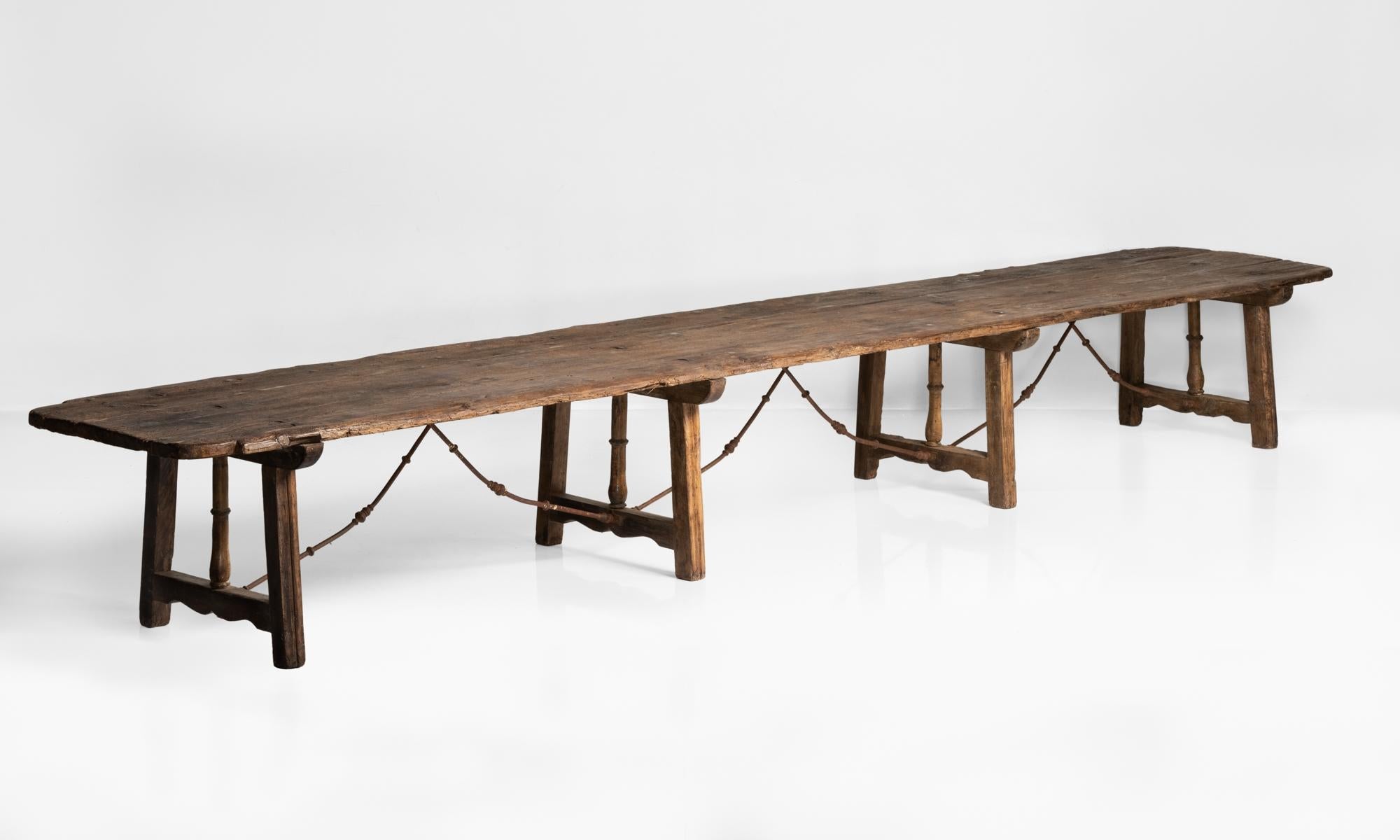 An incredibly rare, massive dining table with iron supports, a plank top and wonderful patina.