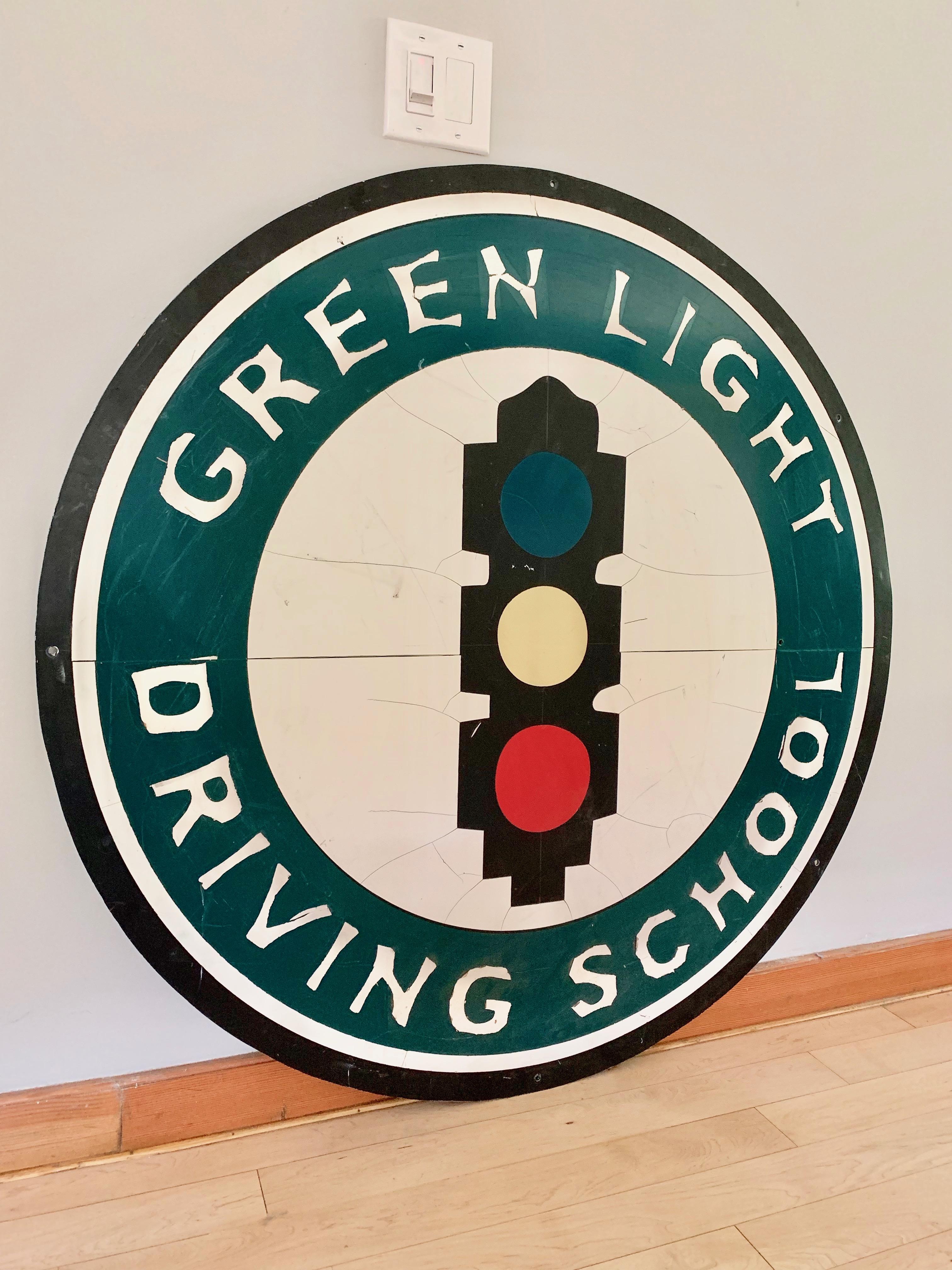 Great vintage sign just under 4 feet in diameter. Sign depicts the green light driving school from California. Cool graphics and coloring. Fun piece of wall-art.