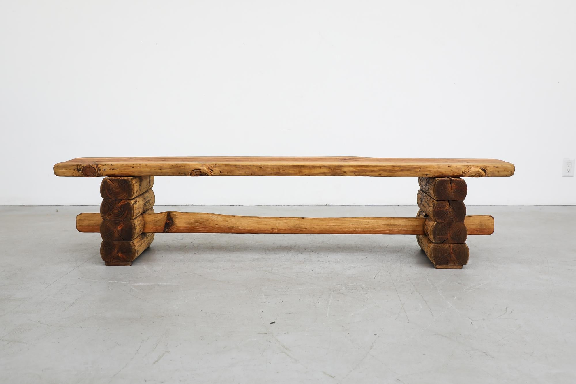 Truly massive midcentury log benches with hand-carved organic live edges, stacked log legs and a center support beam. Benches vary. Both are in original condition with visible wear including scratches. Wear is consistent with their age and use.