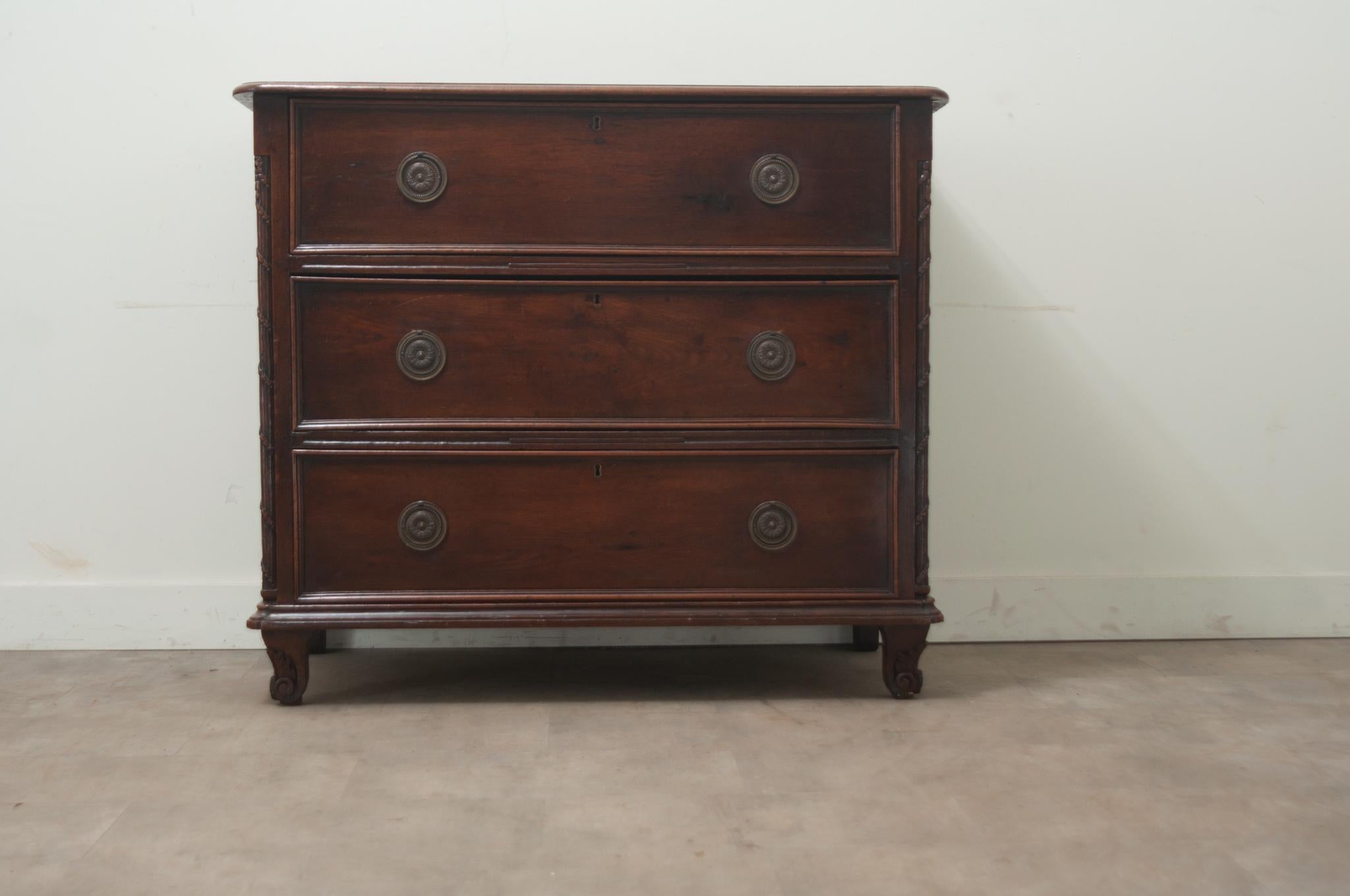 A massive solid oak chest of drawers from the early 1800’s. This large chest has three easy-to-use drawers with patinated brass ring pulls. The front corners are carved from the top all the way down to the cabriole legs. The sides are made of reeded