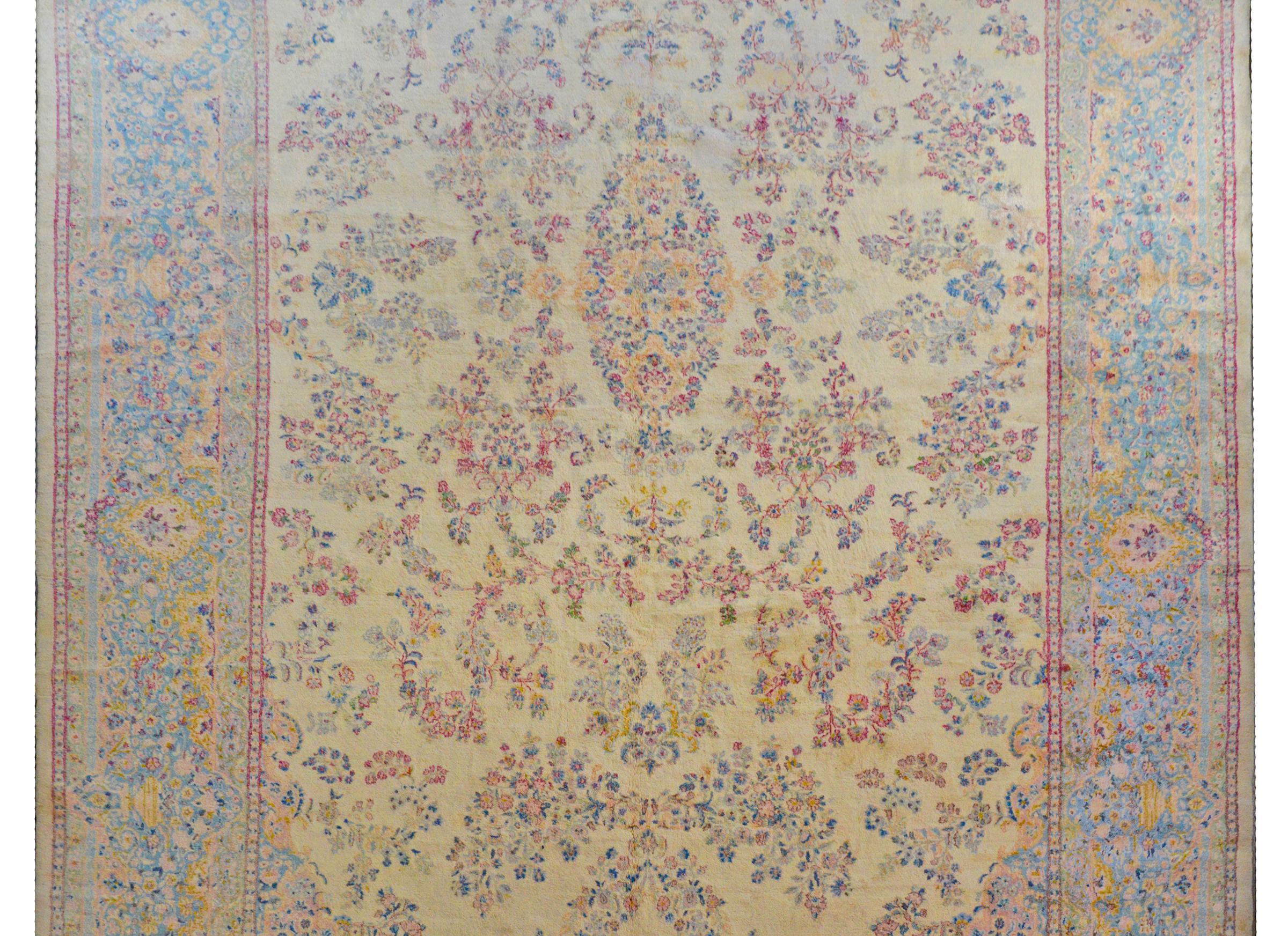 Ein massiver persischer Kirman-Teppich aus dem frühen 20. Jahrhundert mit einem wunderbaren All-Over-Blumen- und Blattmuster in Rosa, hellem Indigo, Gold und Hellgrün, alles auf einem hellgelben Hintergrund. Die Bordüre ist typisch mit einem ähnlich
