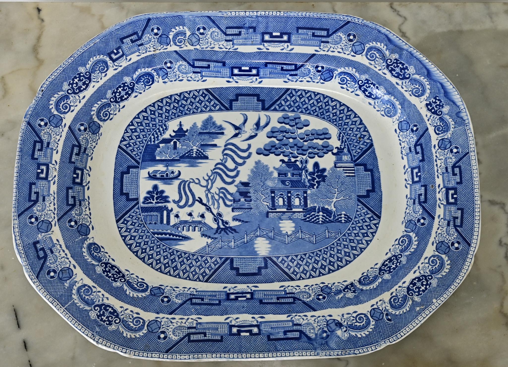 Superbe grand plat en saule bleu datant de l'Angleterre du XIXe siècle. Fabriquée dans ce pays vers 1840, cette magnifique pièce bleue et blanche émerveillera vos invités en tant qu'objet d'art ou en tant que plat de service pour des occasions
