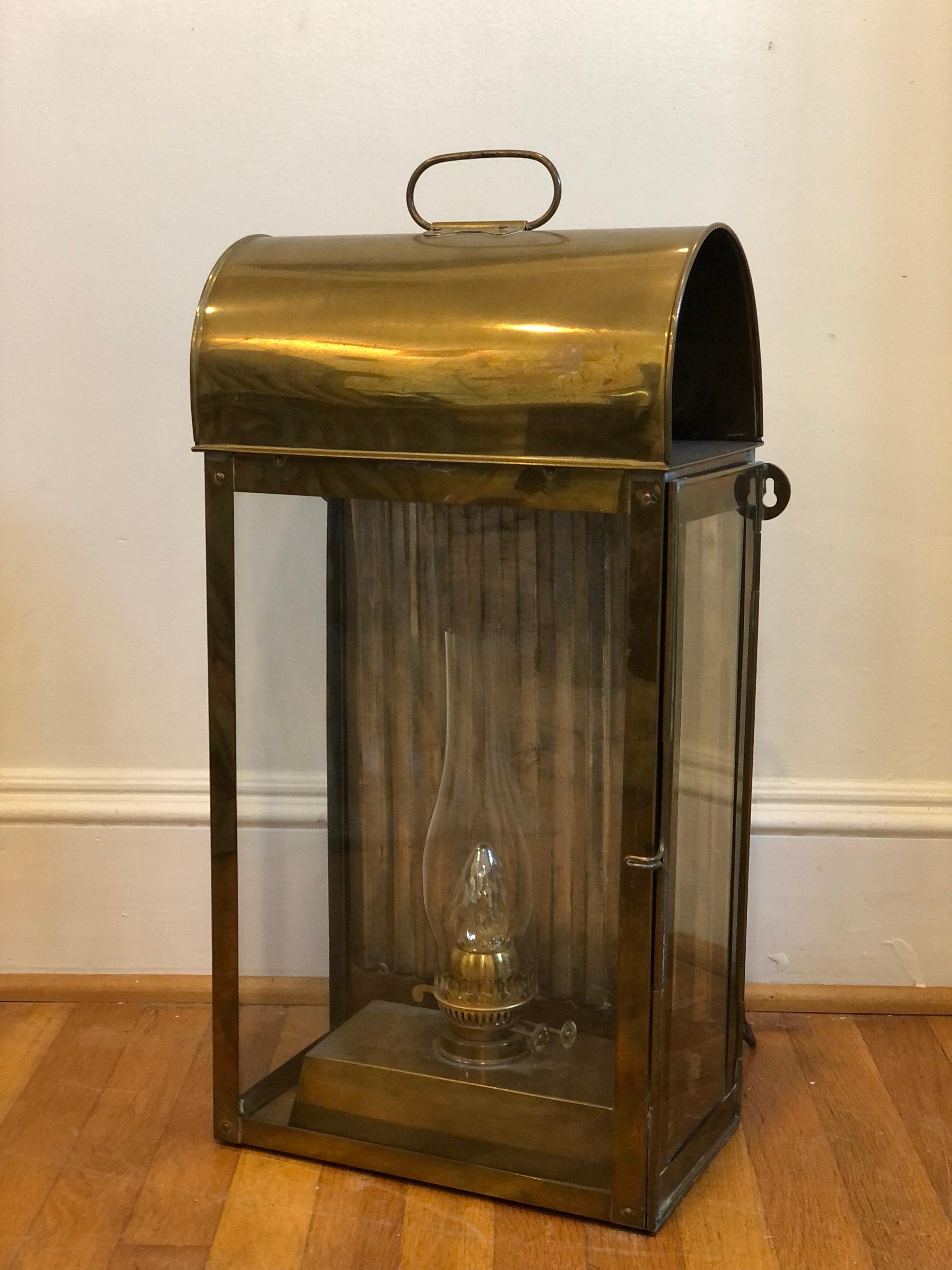 Massive sized Davey and Company style ship kerosine lamp (has been wired for electric).
Stamped Made In England.
This lantern features a Classic rectangular body with an arched top and a brass handles. The lantern has three beveled glass panels