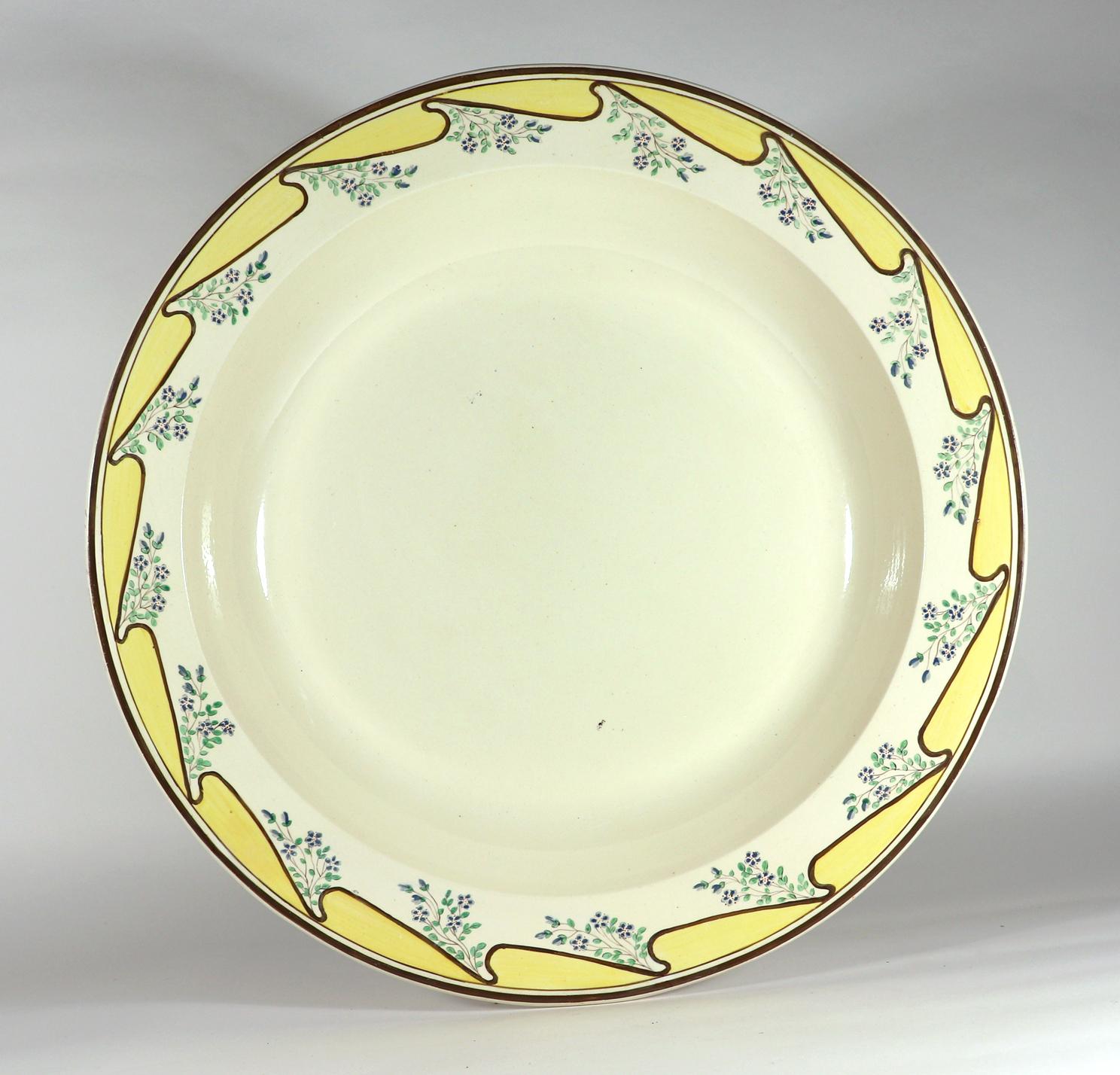 Massive English Creamware Pottery Yellow & Botanical Basin, 
John Shorthose, Shorthose & Heath,
1795-1815

The massive English creamware deep basin has a plain creamware center with the borders painted with a repeating wave of yellow with