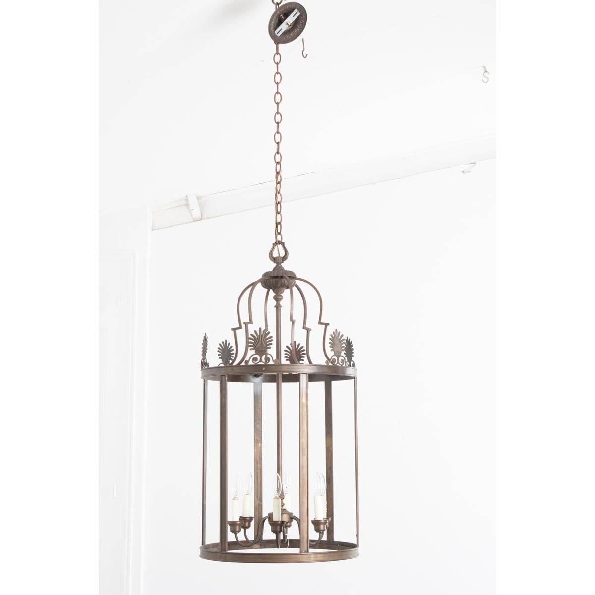 This brass lantern is huge and ready to be installed where a large single fixture is needed. The fixture has two sets of lovely curved brass arches that attach to the nicly decorative crown. Six beautiful floral and scroll ornaments line the