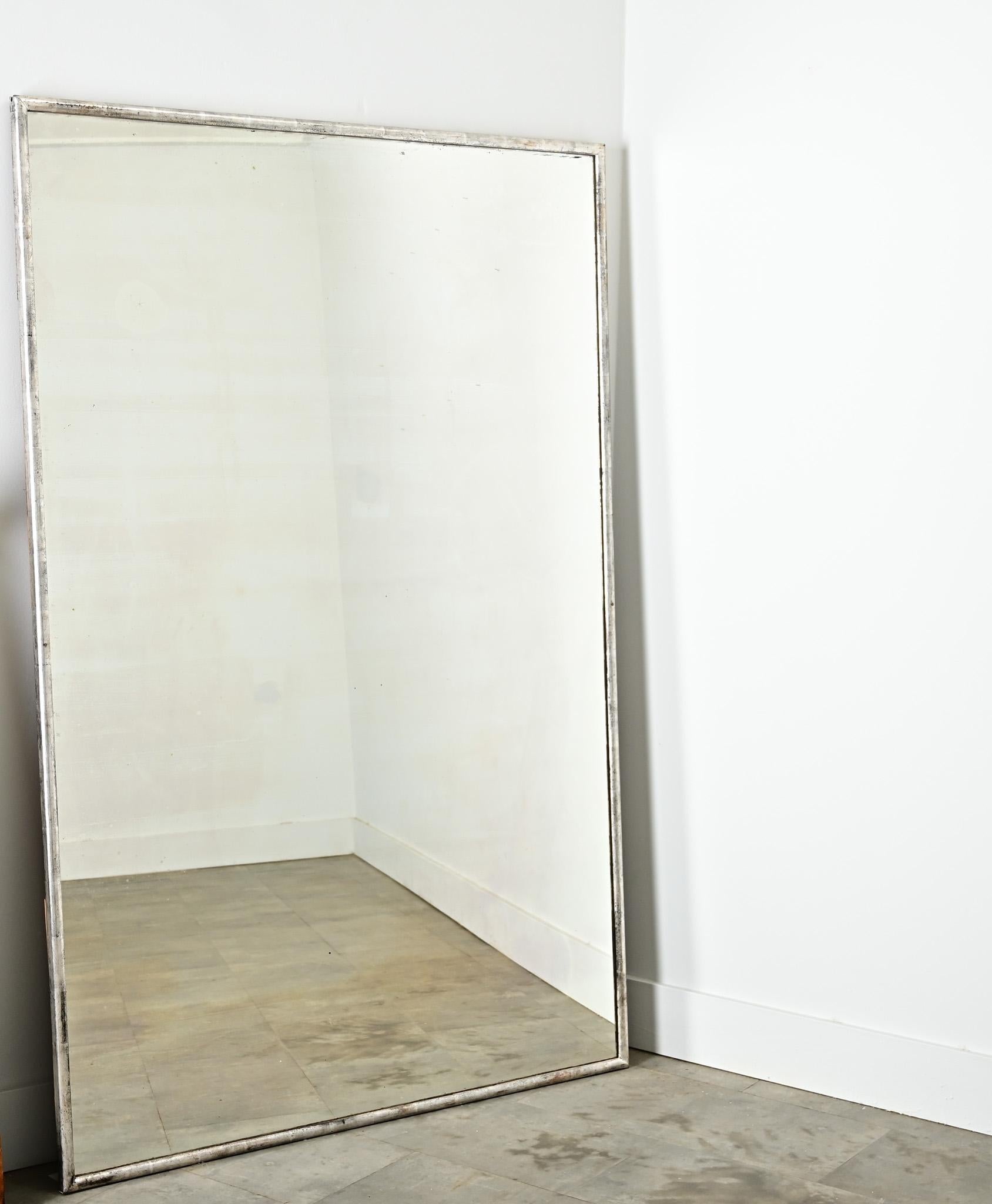 Espejo rectangular de plata dorada del siglo XIX en Francia, con una fantástica pátina que lo envuelve todo. El estrecho marco tiene forma simétrica -puede colgarse en cualquier dirección- y se incorpora fácilmente a cualquier decoración doméstica