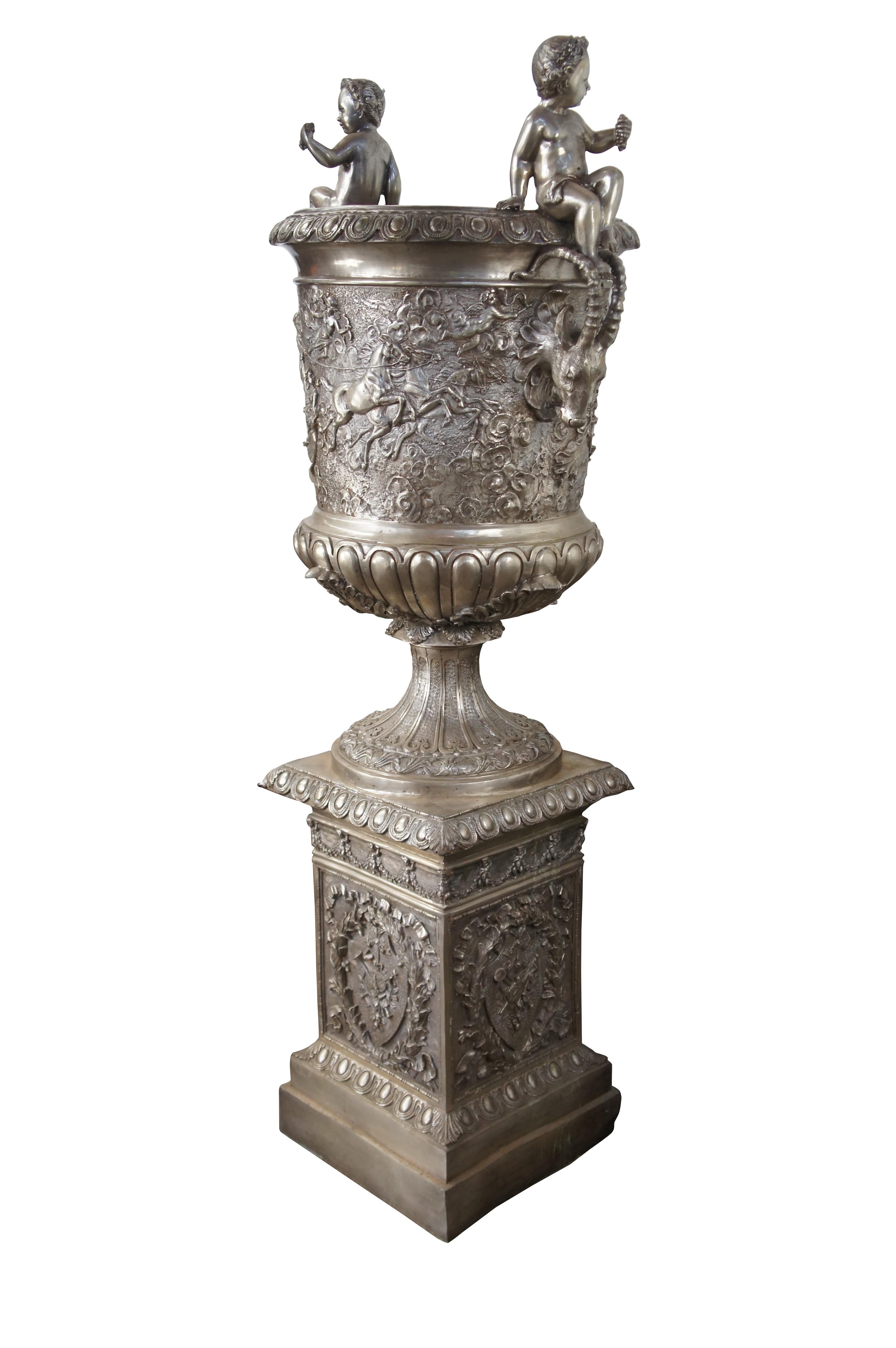 Monumental oversized French Classical figured bronze planters, circa last quarter 20th century. Perfect for display indoor or outdoor. Features figured stags on each side beneath seated cherubs with grapes. The mouth of the urn showcases an egg and