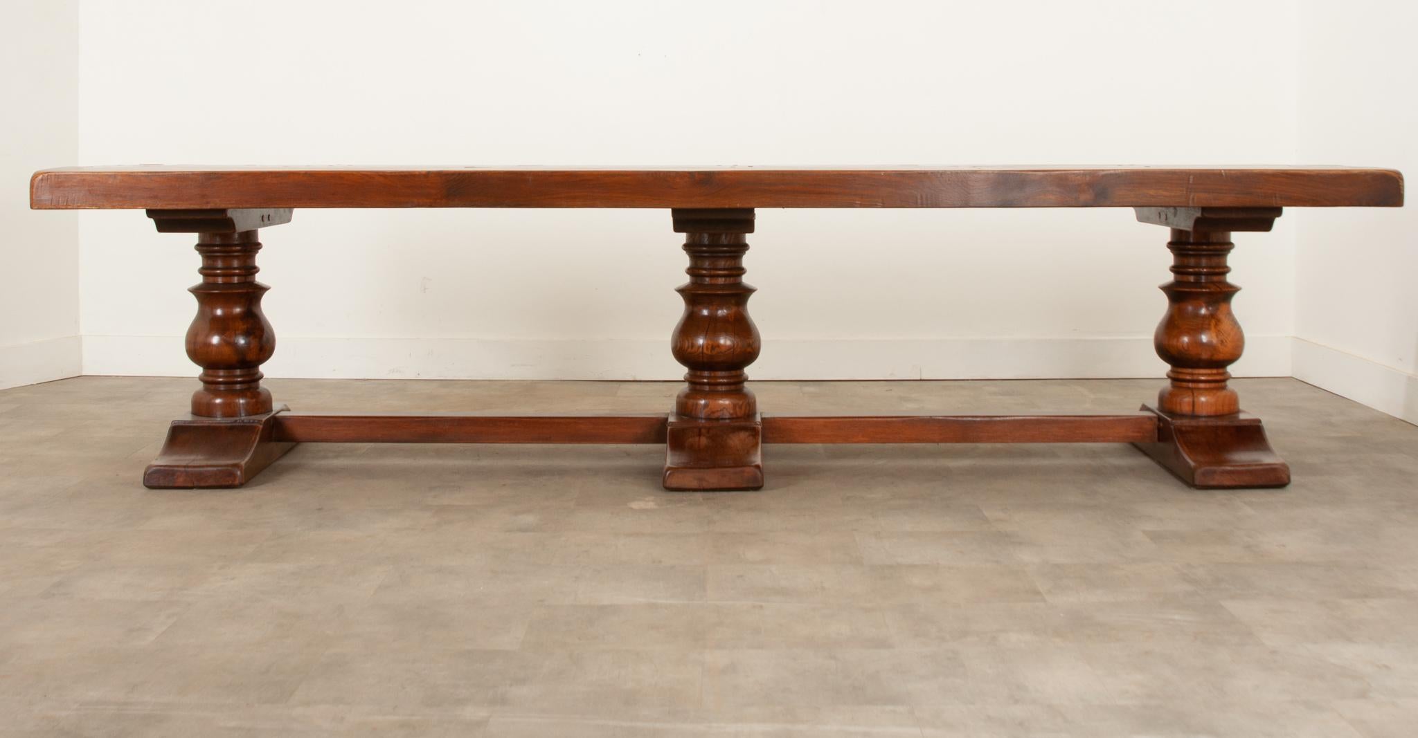 At over 10 feet long this massive French solid oak trestle base table is an absolute showstopper. Dating to the late 19th century it is a magnificent example of skilled craftsmanship. The 3 ½” thick top consists of four solid planks and is the