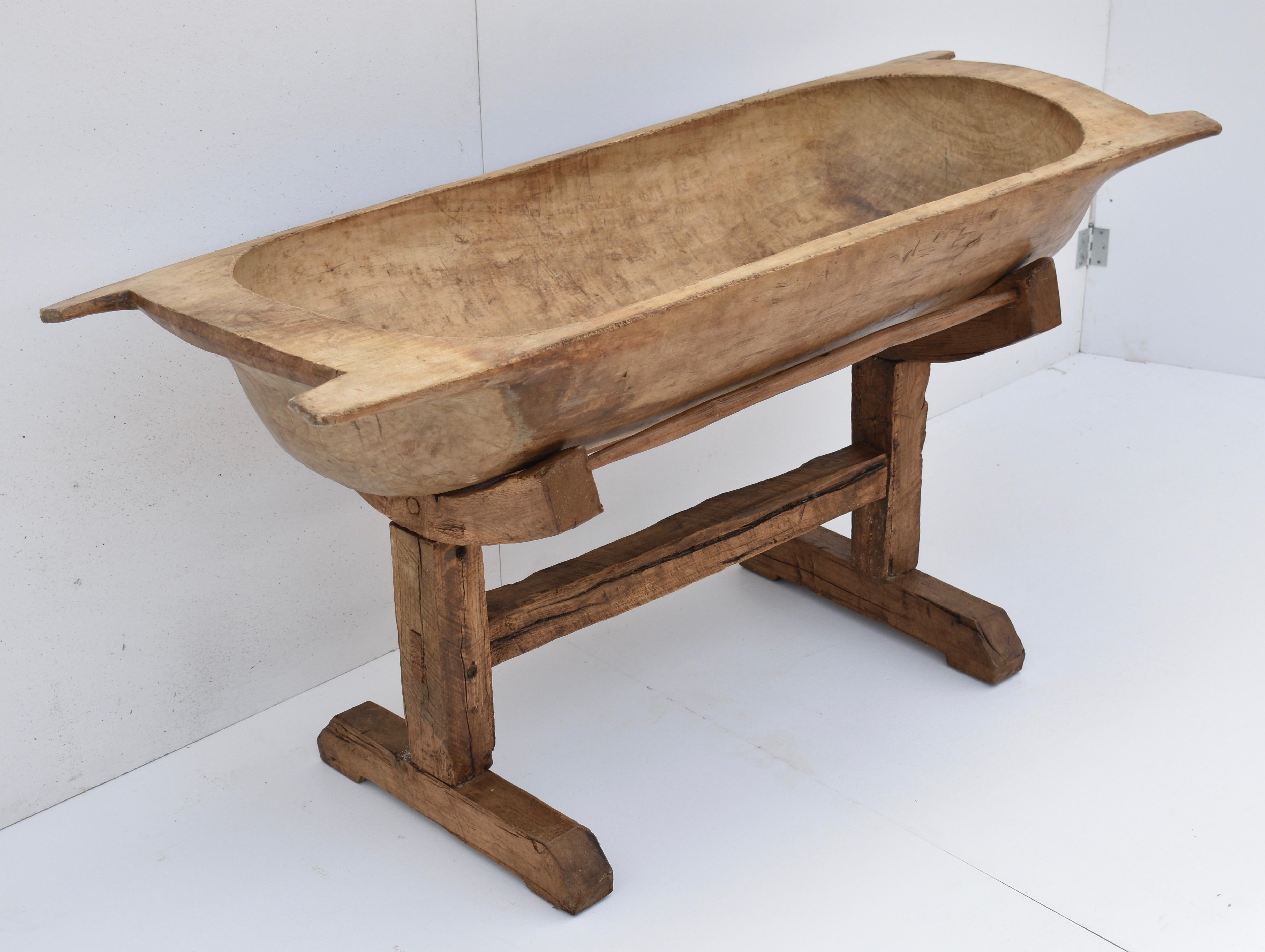 Used for kneading dough for multi-family baking or perhaps for washing the baby, this huge fruitwood trog was hand carved from a single split log. It stands nice and straight with its bottom sitting nicely in the curved supports of this stand. The
