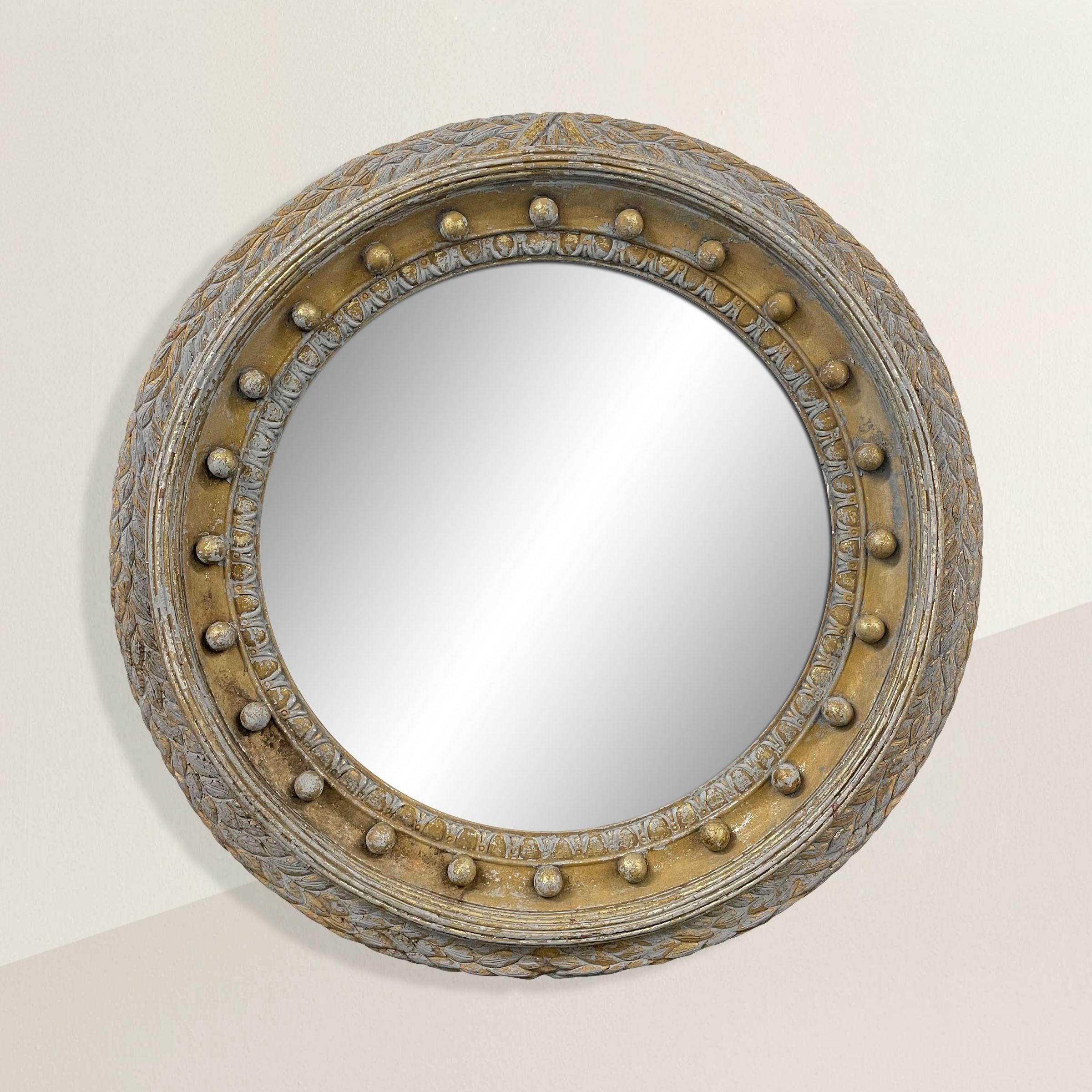 An impressive 20th century gilt and painted framed round mirror with classical Georgian-inspired motifs including repeated spheres, acanthus leaves, ribbons, and egg and dart molding. A wonderful size to anchor any room, and chic enough to mix with